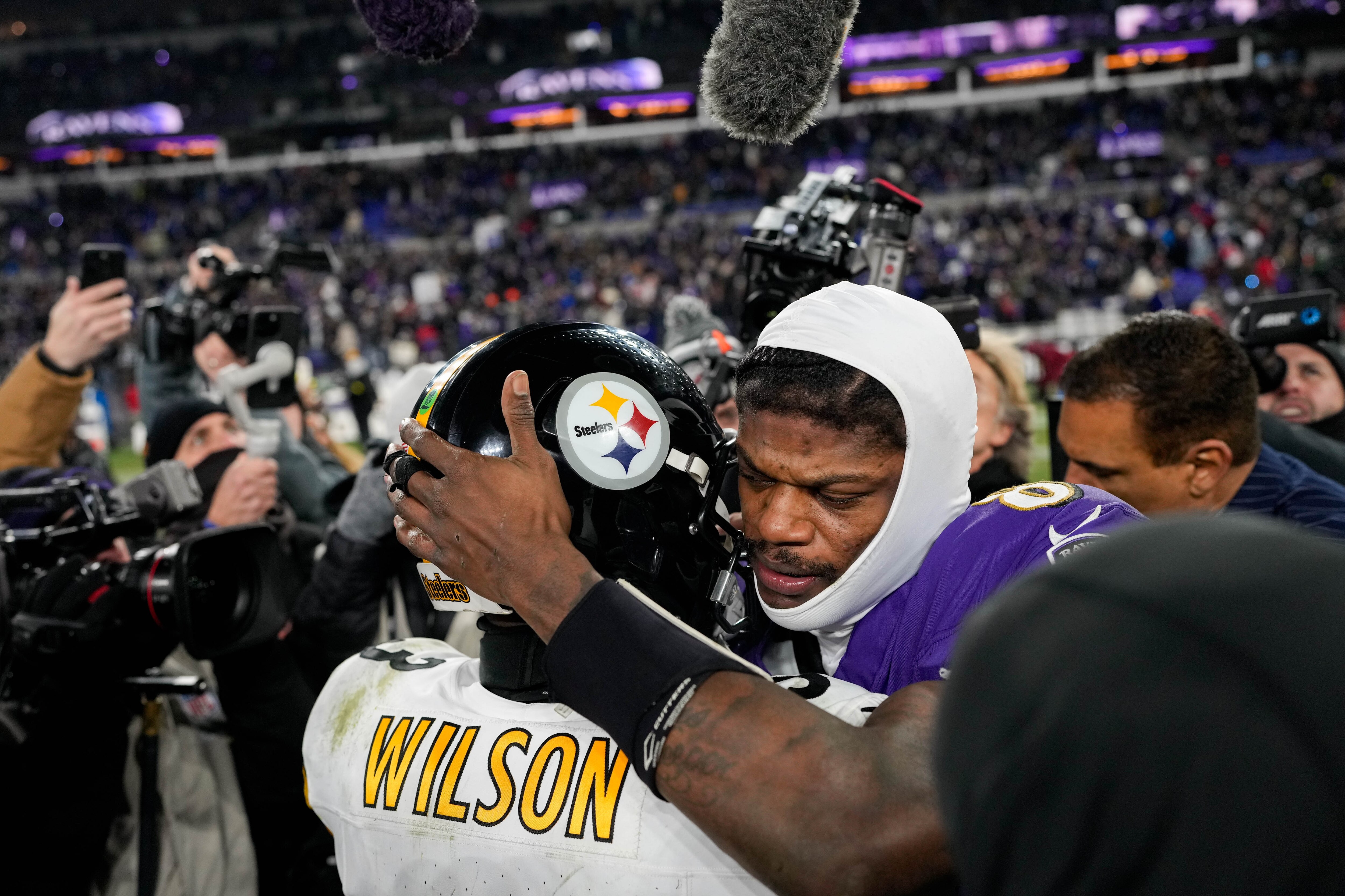 Baltimore Ravens quarterback Lamar Jackson (8) embraces Pittsburgh Steelers quarterback Russell Wilson (3) after defeating them 28-14 in the AFC wild card playoff game at M&T Bank Stadium on Saturday, January 11, 2025.