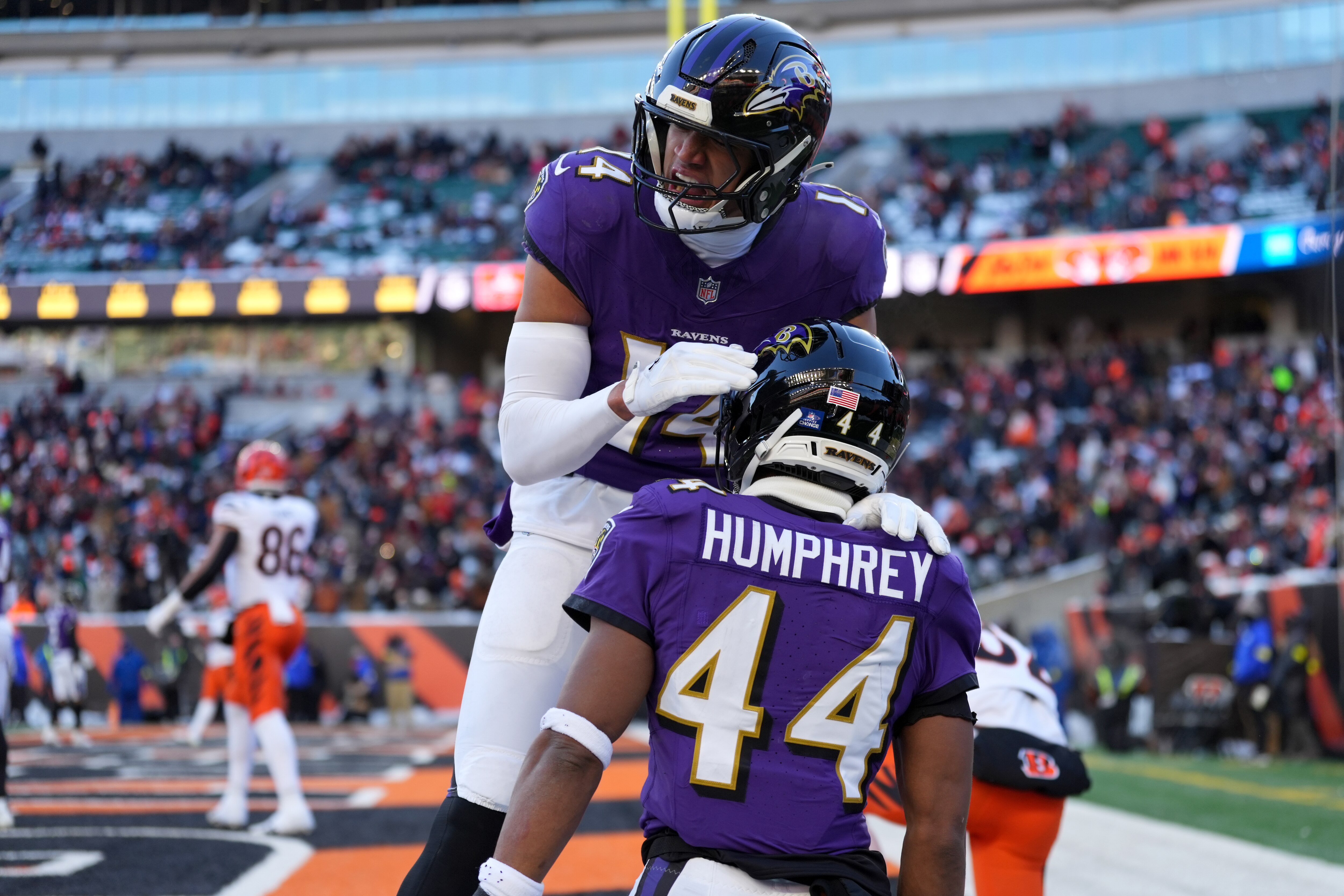 Baltimore Ravens safety Kyle Hamilton (14), top, congratulates Baltimore Ravens cornerback Marlon Humphrey (44), right, after defending a pass in the end zone during an NFL football game against the Cincinnati Bengals.