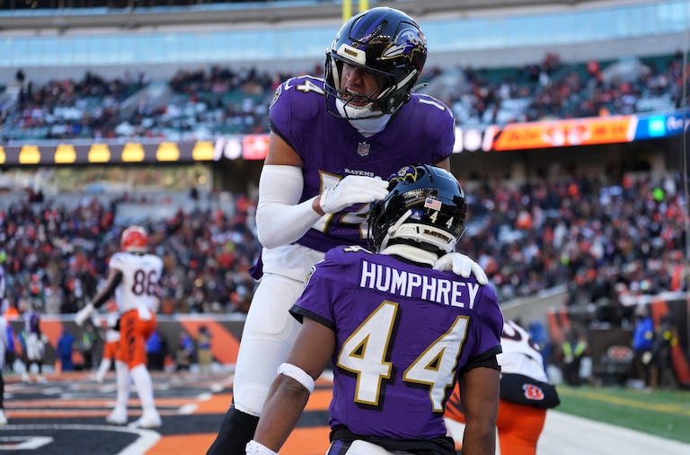 Baltimore Ravens safety Kyle Hamilton (14), top, congratulates Baltimore Ravens cornerback Marlon Humphrey (44), right, after defending a pass in the end zone during an NFL football game against the Cincinnati Bengals.