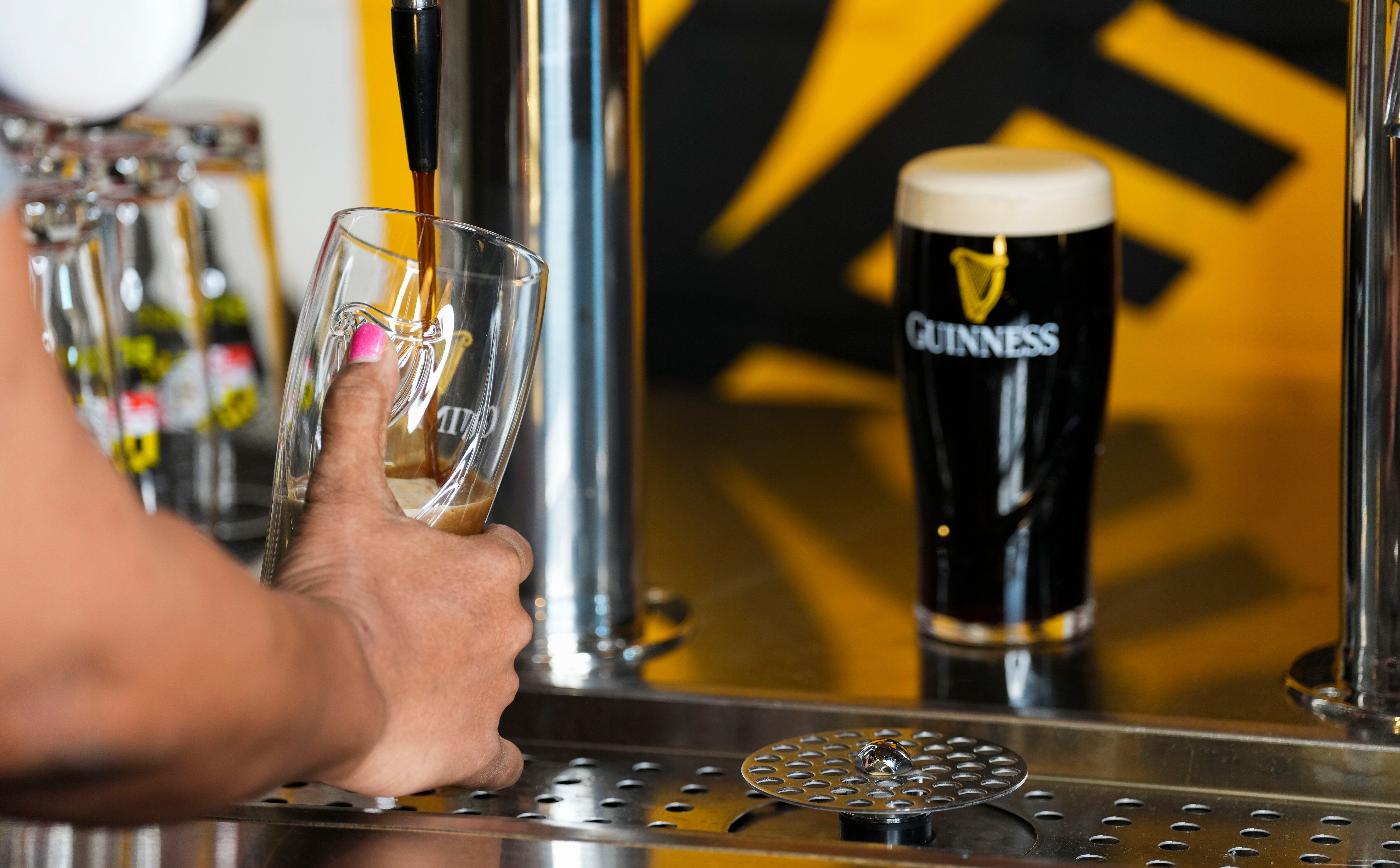Baltimore Banner columnist Leslie Streeter learns from Oliver Gray how to craft the "perfect pour" of a Guinness draft at the Baltimore Guinness location on March 14, 2023.