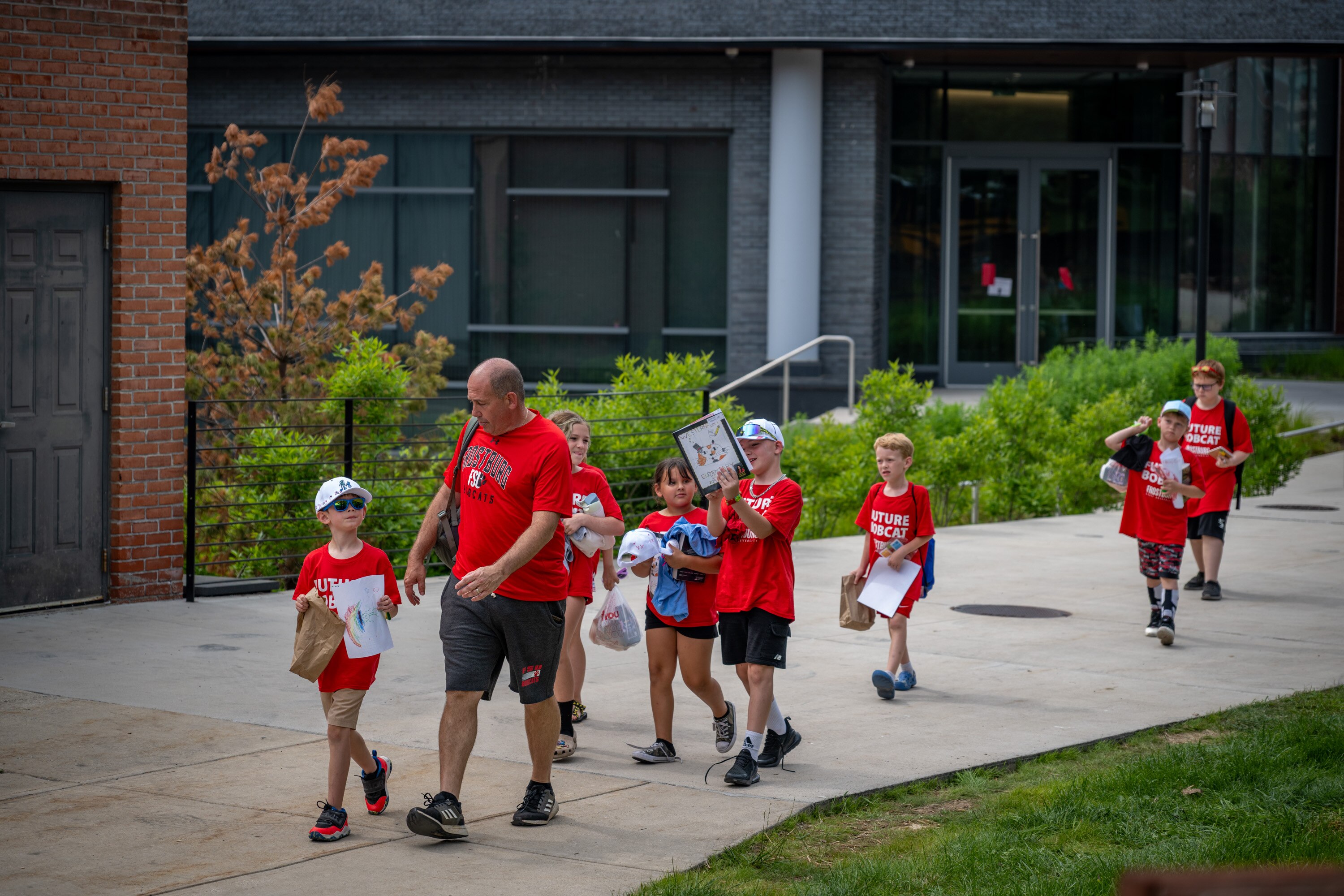 Westernport Elementary School Principal Derek Horne leads a group of students to their bus at the end of the school day at Frostburg State University on Thursday.