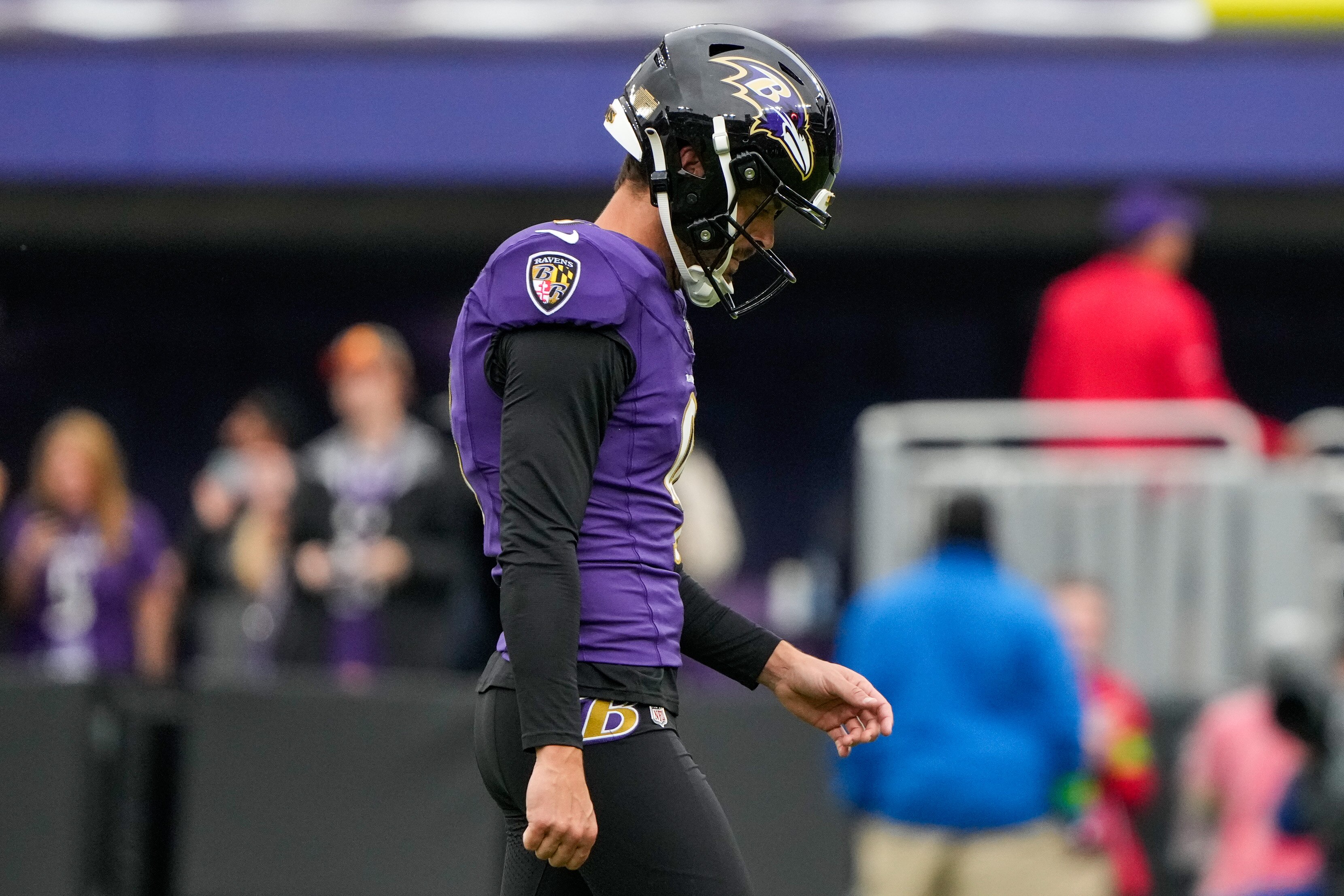 Ravens kicker Justin Tucker walks off the field after missing a 61-yard field goal at the end of regulation.