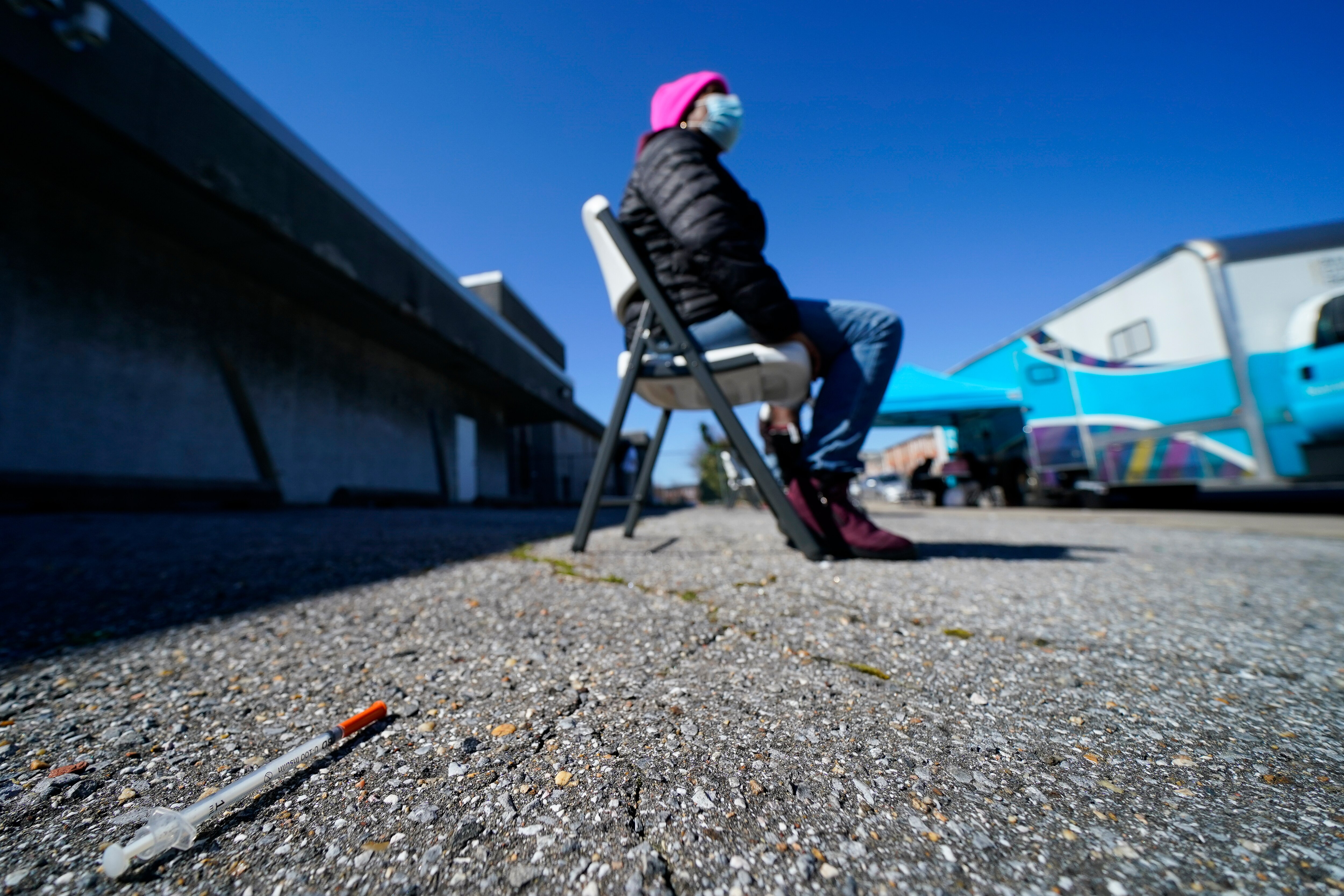 A syringe is seen on the ground as Lisa McFadden waits to be treated near a Baltimore City Health Department RV, Monday, March 20, 2023, in Baltimore. The Baltimore City Health Department's harm reduction program uses the RV to address the opioid crisis, which includes expanding access to medication-assisted treatment by deploying a team of medical staff to neighborhoods with high rates of substance abuse and offering buprenorphine prescriptions.
