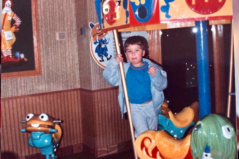 Daniel Dean next to the merry go round he broke his arm on at Eastpoint Mall. Photo was probably taken in the late 1980s.