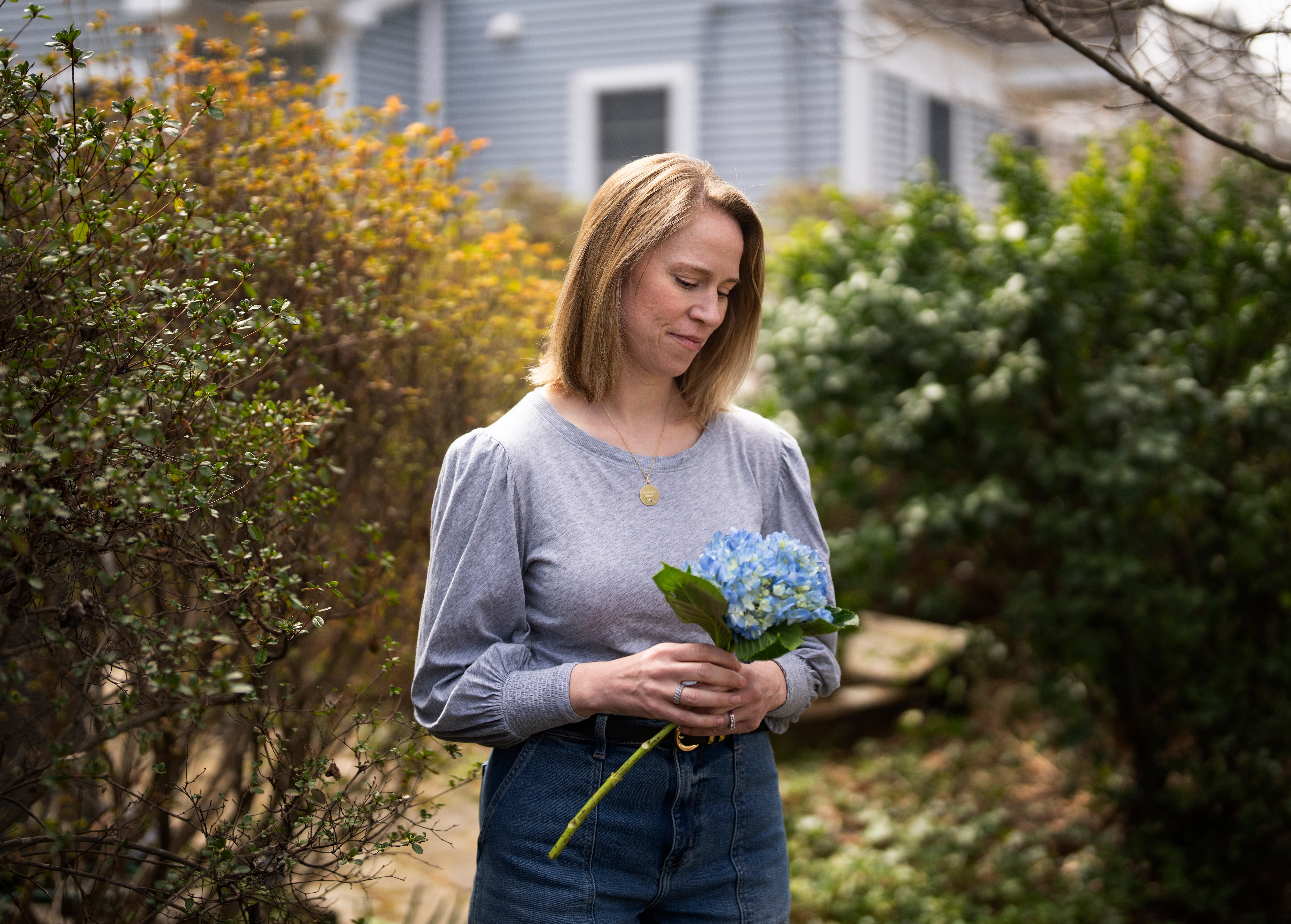 Jessica Brady Reader poses for a portrait in the front yard of her home in Kensington, Tuesday, March 25, 2025. Reader holds flowers that remind her of daughter Francesca.