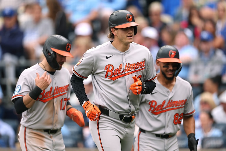 Coby Mayo #16 of the Baltimore Orioles is congratulated by Colton Cowser #17 and Jeremiah Jackson #82 after hitting a home run during the 6th inning of the game against the Kansas City Royals at Kauffman Stadium on April 22, 2026 in Kansas City, Missouri.