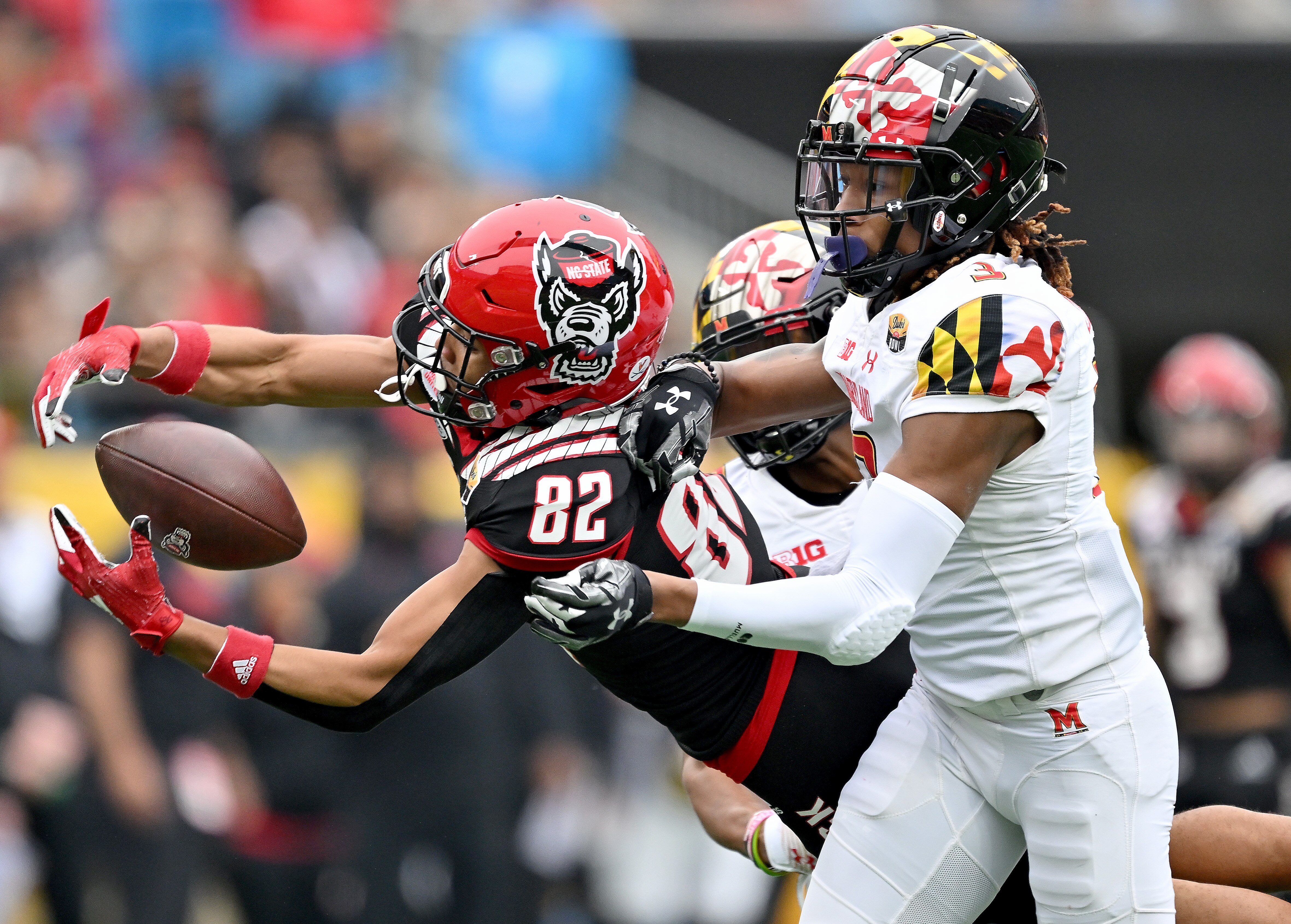 Deonte Banks #3 of the Maryland Terrapins defends a pass to Terrell Timmons Jr. #82 of the North Carolina State Wolfpack during the first half of the Duke's Mayo Bowl at Bank of America Stadium on December 30, 2022 in Charlotte, North Carolina.