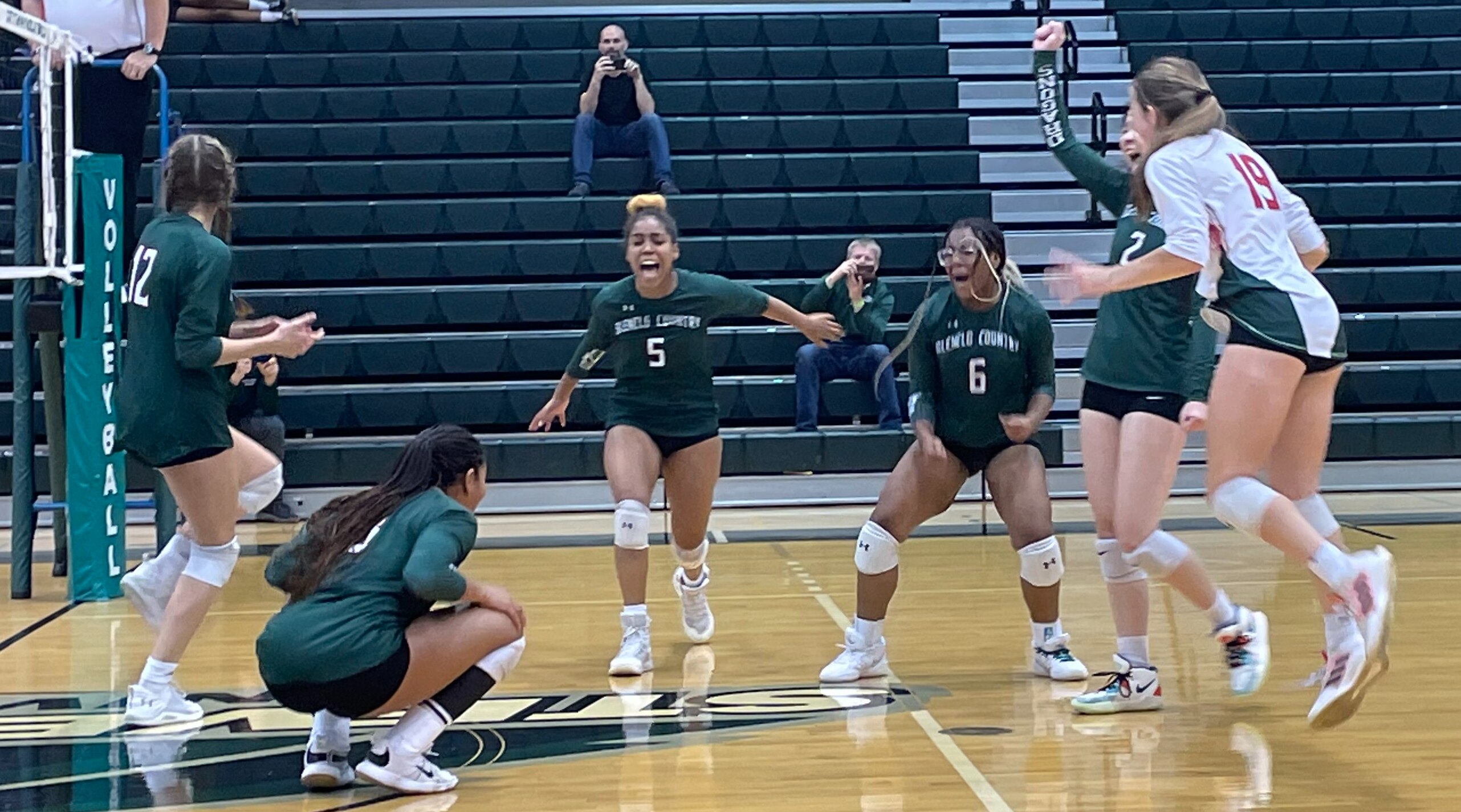 Glenelg Country School's volleyball team celebrates after securing the winning point in Sunday's IAAM C Conference final at Stevenson University. The Dragons swept previously undefeated Chapelgate Christian.