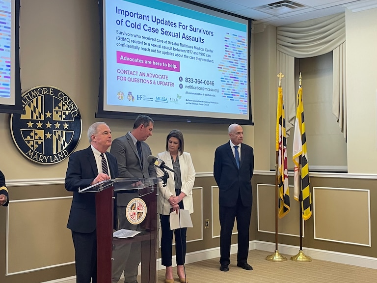 Baltimore County State’s Attorney Scott Shellenberger, County Executive Johnny Olszewski, TurnAround Executive Director Amanda Rodriguez, and GMBC CEO John B. Chessare, MD, gather at the podium following a press conference addressing rape kits that need to be tested. Some of the victims have been waiting for nearly 50 years for the results.