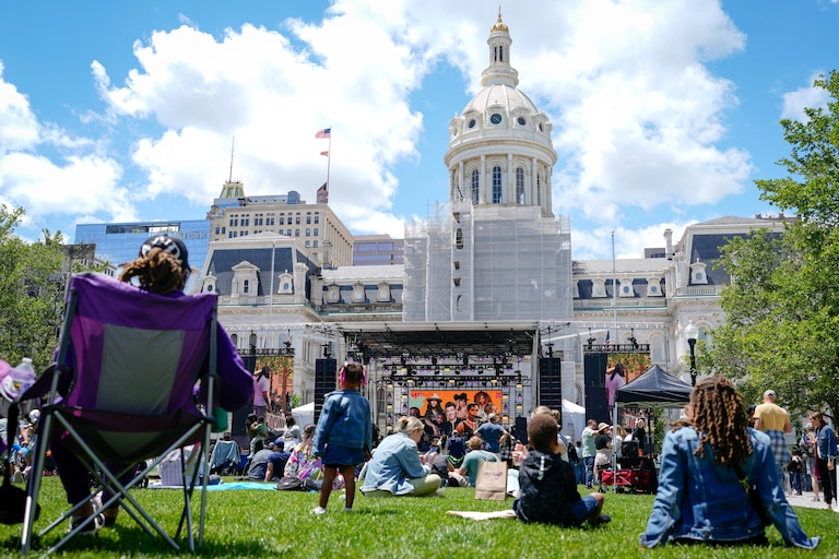 Attendees sit in the plaza in front of City Hall where the main stage is set up at Artscape in downtown Baltimore, Md. on Saturday, May 24, 2025.