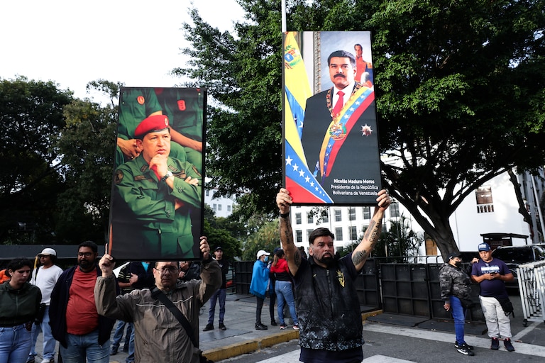 CARACAS, VENEZUELA - JANUARY 03: Supporters of Nicolas Maduro and late Hugo Chavez hold posters with their images after explosions and low-flying aircraft were heard on January 03, 2026 in Caracas, Venezuela. According to some reports, explosions were heard in Caracas and other cities near airports and military bases around 2 am. US President Donald Trump later announced that his country's military had launched a "large-scale" attack on Venezuela and captured its President Nicolas Maduro and his wife.