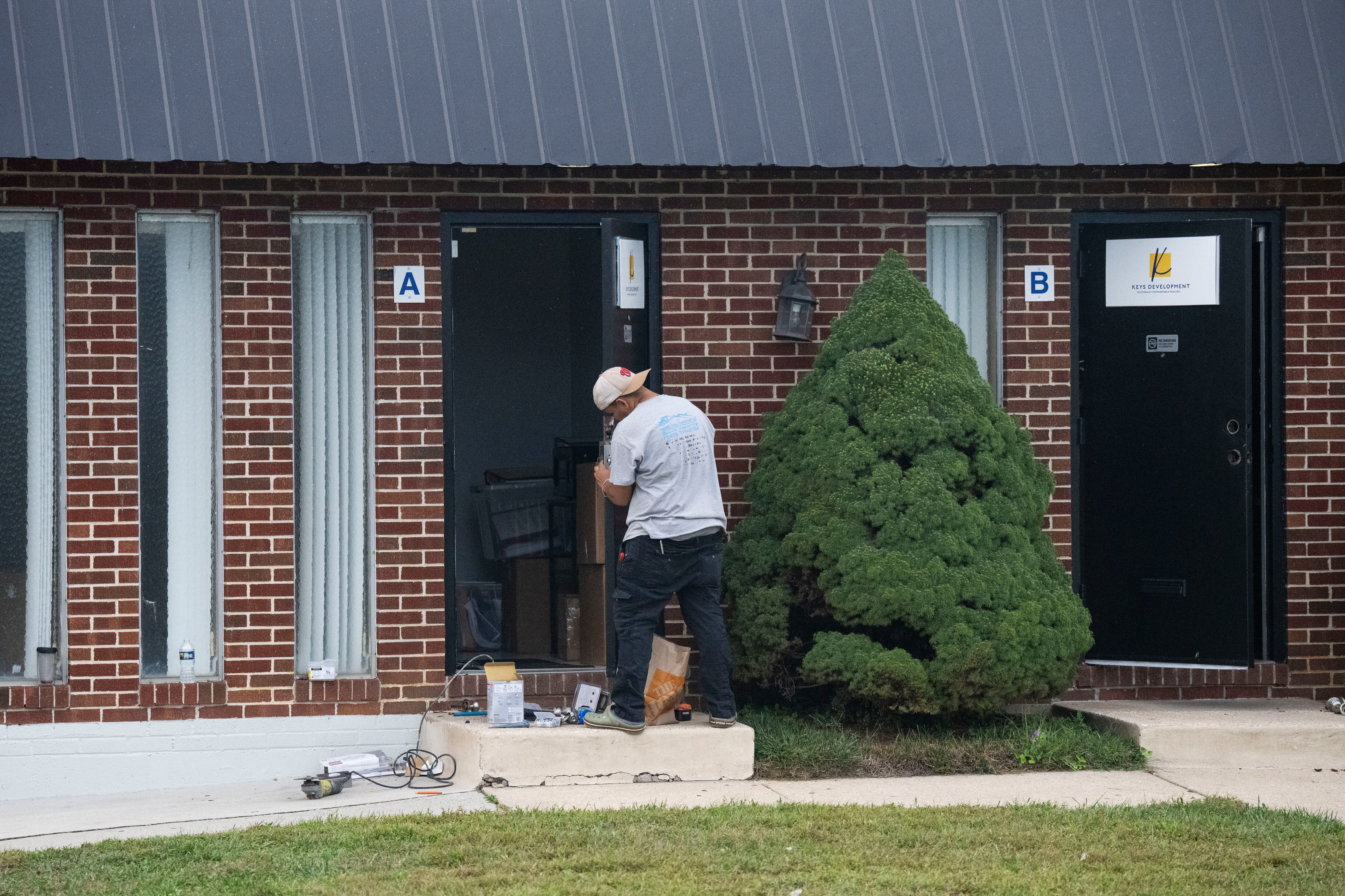 A man repairs a door at the Keys Developments building in Baltimore on Wednesday. The FBI had raided the building earlier that day.