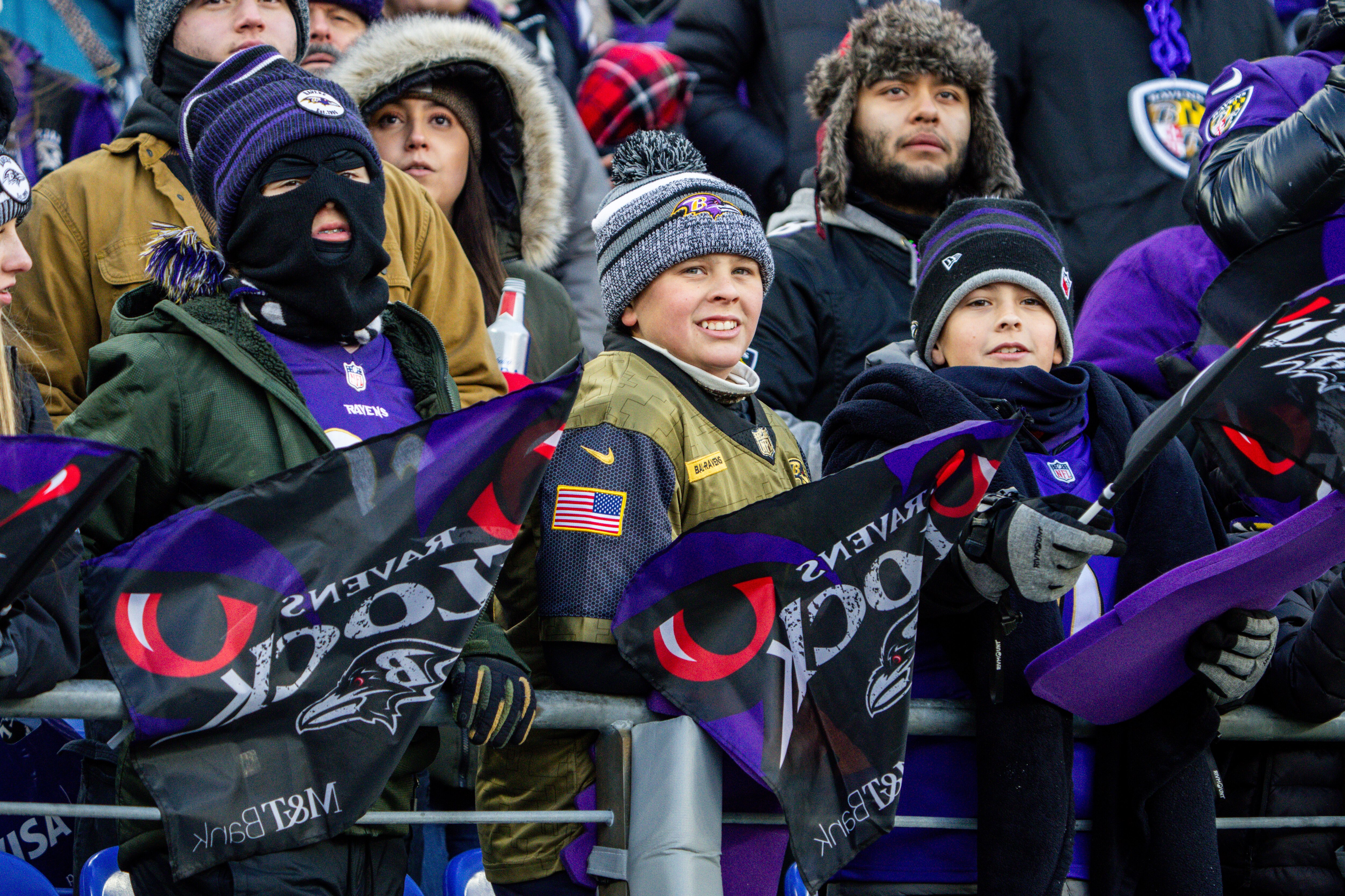 Young fans wave Ravens flags before the game against the Houston Texans at M&T Bank Stadium last week. Temperatures were in the 20s. The weather should be milder Sunday, with light showers.