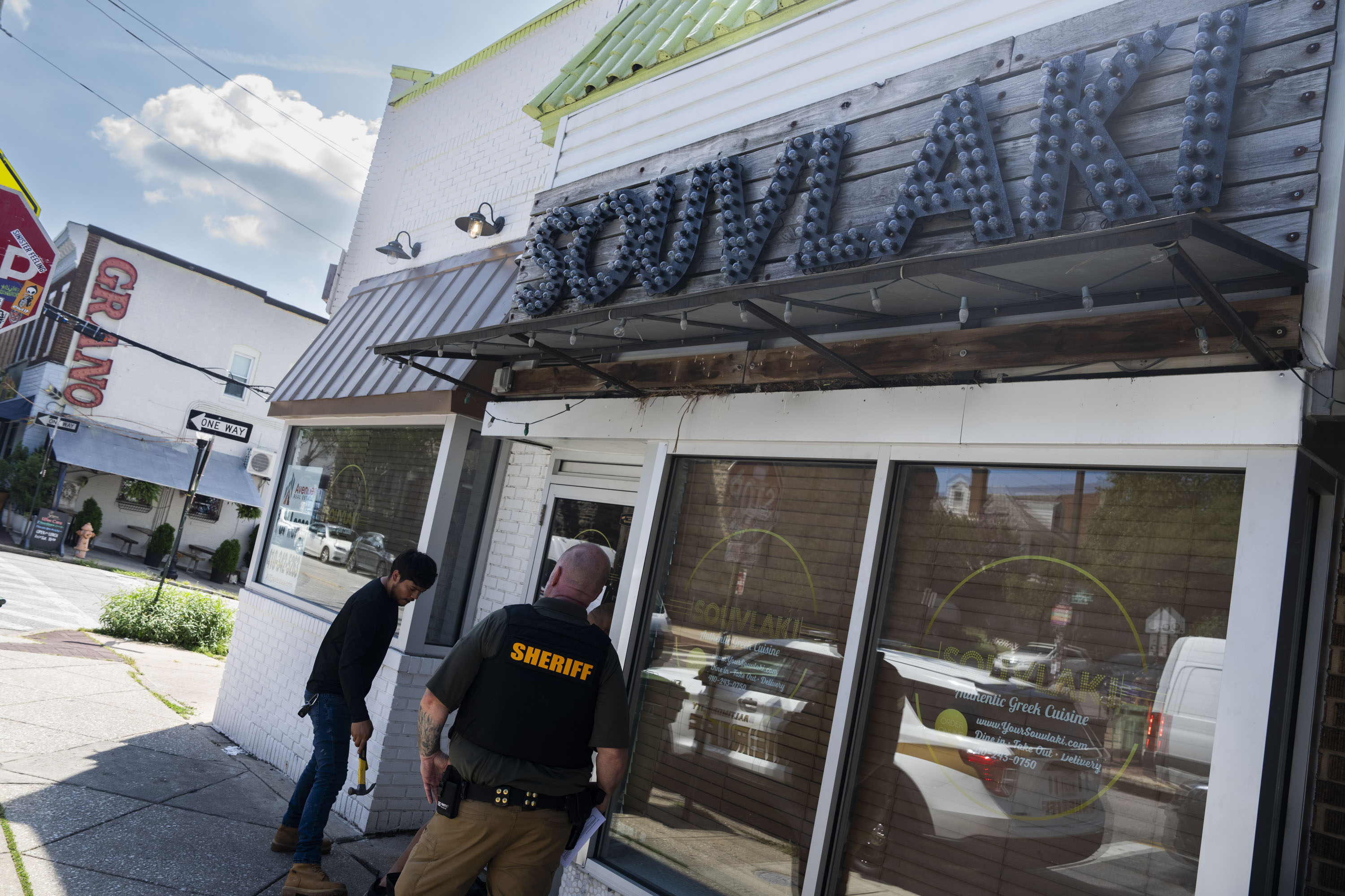 A Baltimore City Sheriff outside of the now-closed Souvlaki on Monday.
