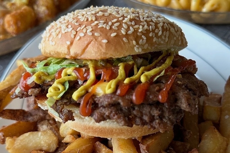 The Royal Blue's smashburger comes with bacon and the option to add a runny egg for brunch.