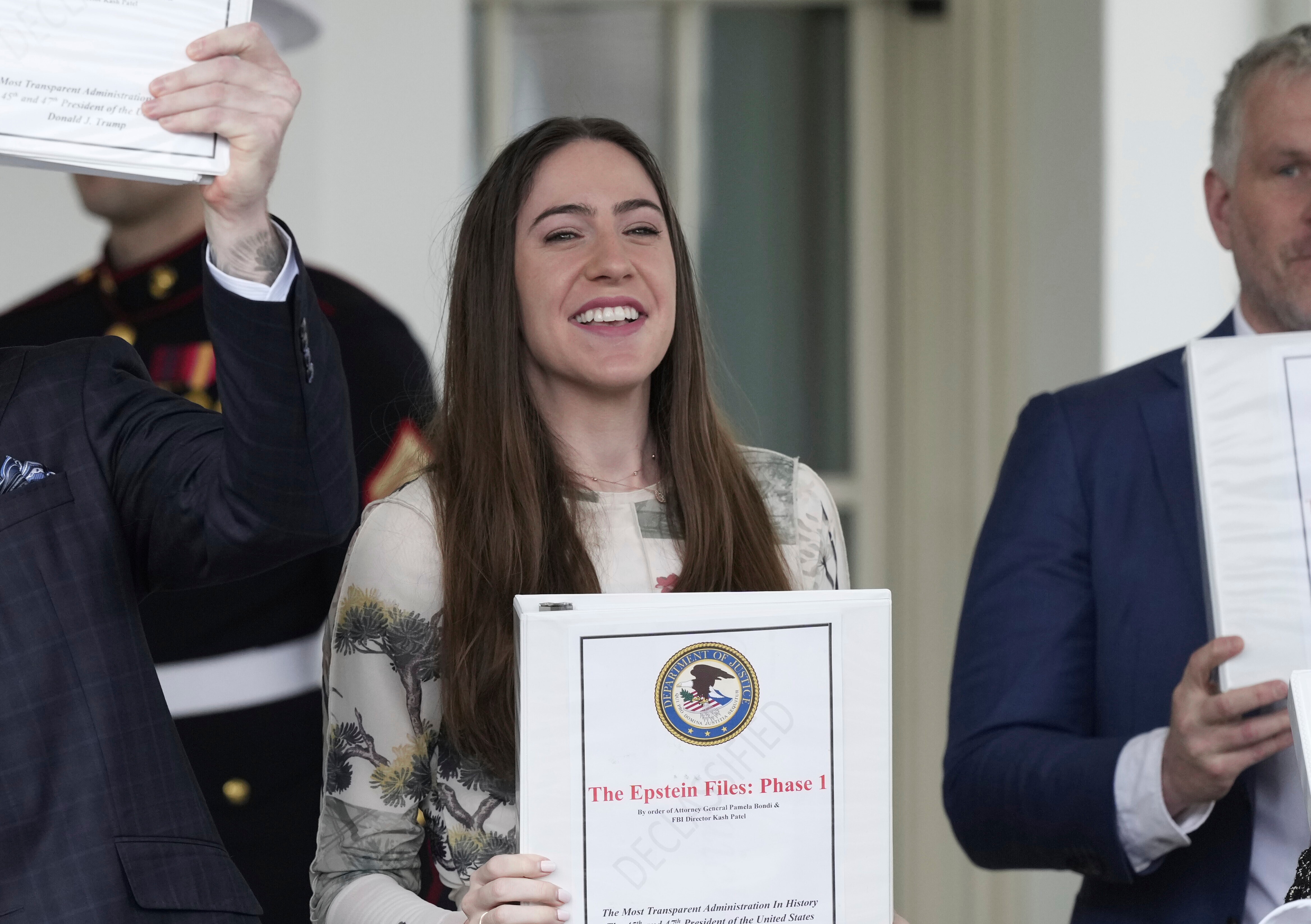 Conservative political commentator Rogan O'Handley, also known as DC Draino, from left, and social media content creator Chaya Raichik, hold up binders with a cover titled "The Epstein Files: Phase 1" at the White House, Thursday, Feb. 27, 2025, in Washington.  (AP Photo/Ben Curtis)