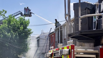 Baltimore City Fire responds to a three-alarm fire that erupted through upper levels of rowhomes in the Barclay neighborhood of Baltimore on Thursday afternoon.