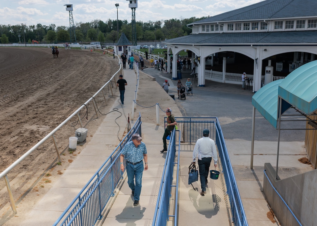 Guests and workers move around the Laurel Park Race Track grounds.