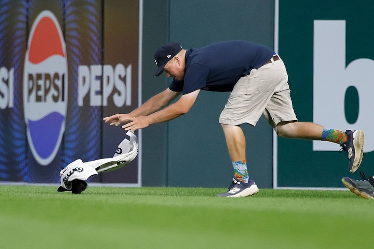 A member of the Comerica Park ground crew captures a squirrel in center field during the seventh inning of Monday night's Orioles-Tigers game.