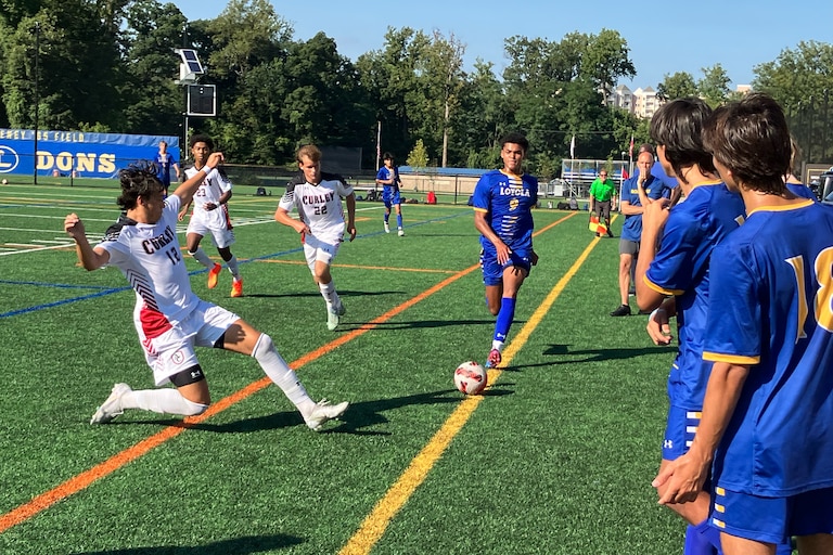 Archbishop Curley senior back Trey Magnaye (left) makes a sliding attempt to prevent Loyola Blakefield sophomore Sammie Walker from advancing toward goal as Friar teammate Mason Cook approaches. Curley beat the Dons, 3-0, on Wednesday afternoon.