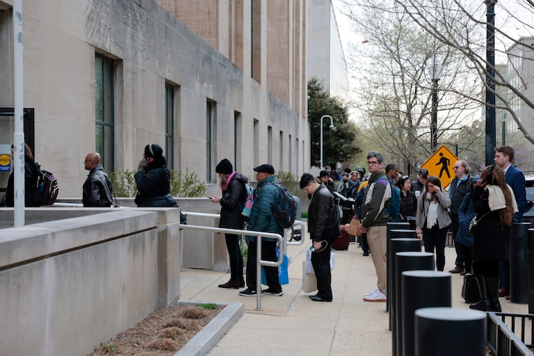 Employees of the Department of Health and Human Services (HHS) stand in line to enter the Mary E. Switzer Memorial Building on April 02, 2025 in Washington, DC. Layoffs began earlier this week at the Health and Human Service Administration offices after it was announced last week that the Trump Administration plans to cut 10,000 jobs at HHS.