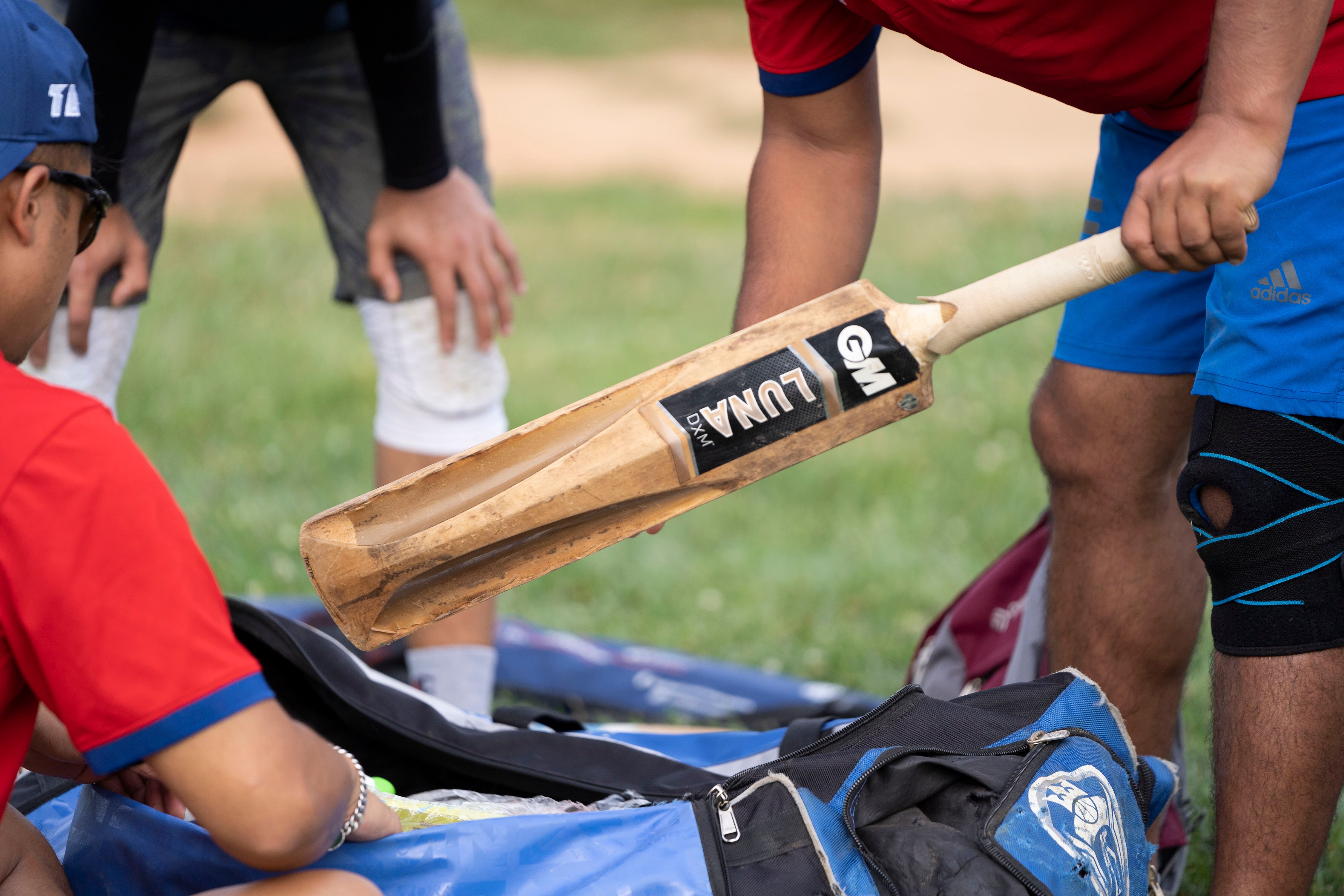 Saathi Baltimore Cricket Club members unpack bats, wickets, balls and gloves ahead of practice on July 27.