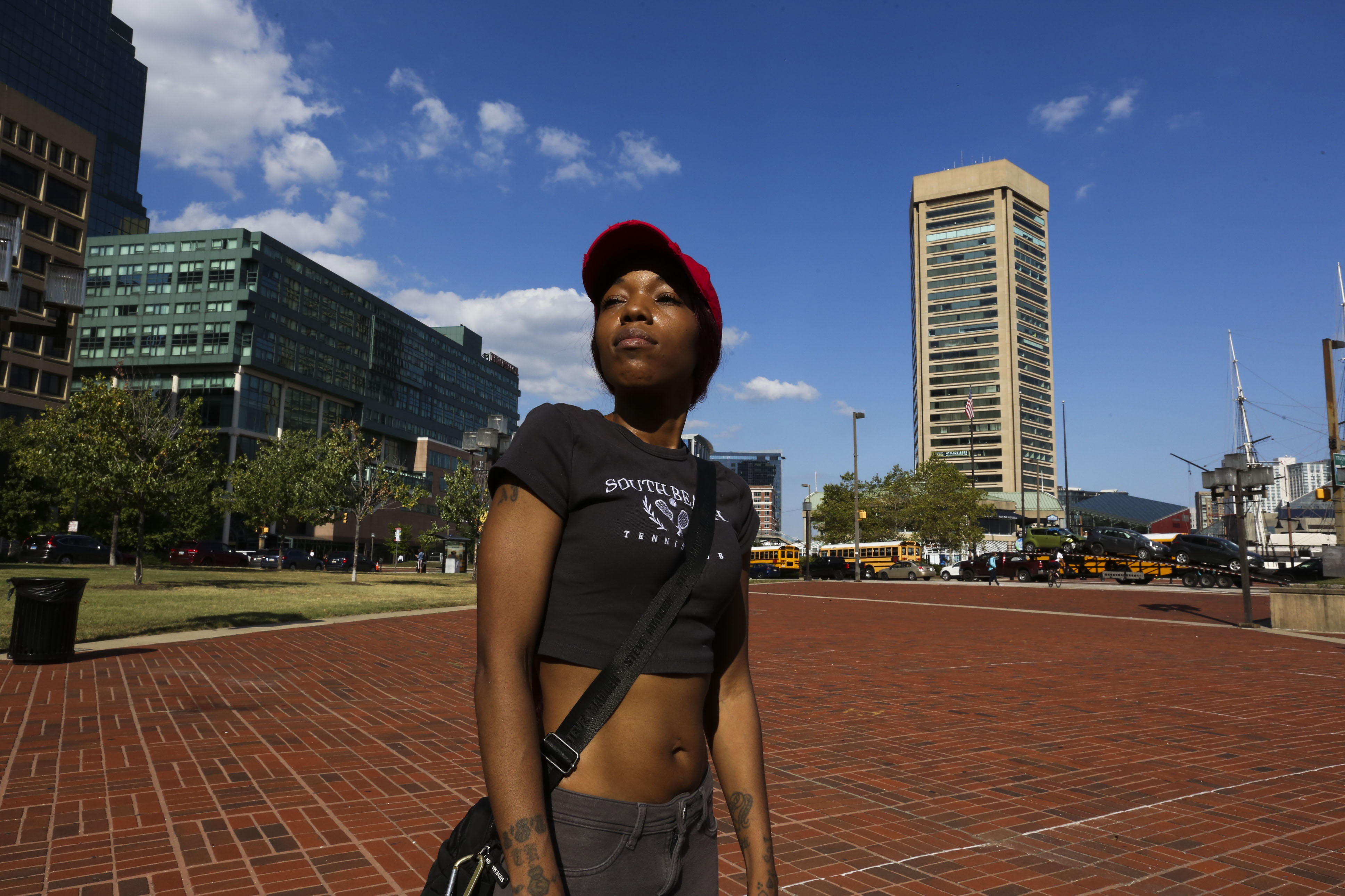 Aijah Gatson, 31, mother of the juvenile charged with murder in the squeegee shooting case, talks with reporters at McKeldin Square on August 3, 2022. She is accompanied by her other son, Tyree Gatson, 9, and her niece Milan Gatson, 11. She was on the phone with her son who is currently in custody.