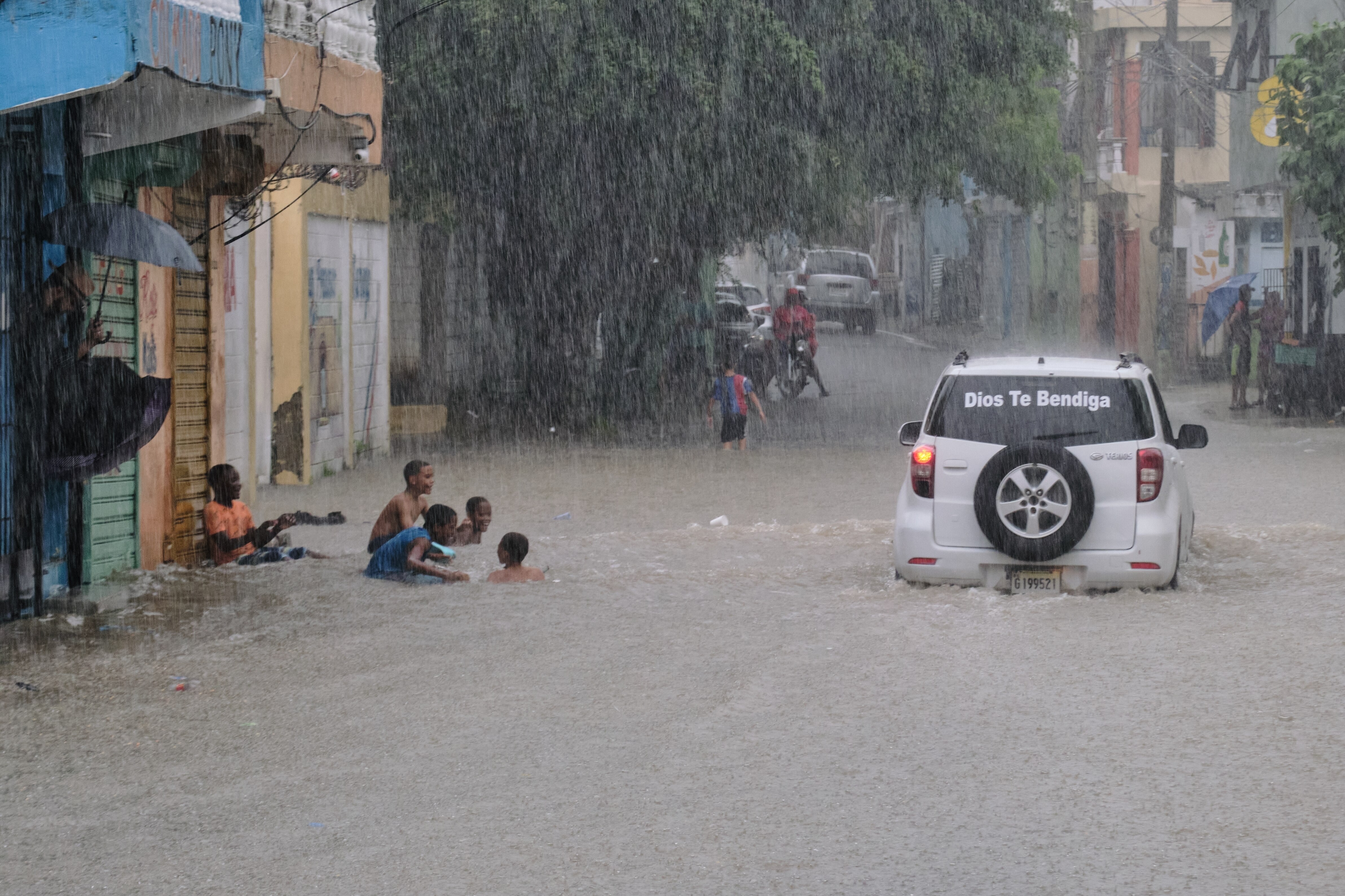 Children play in a street flooded by rains caused by Tropical Storm Melissa in Santo Domingo, Dominican Republic, Friday, Oct. 24, 2025. (AP Photo/Ricardo Hernandez)