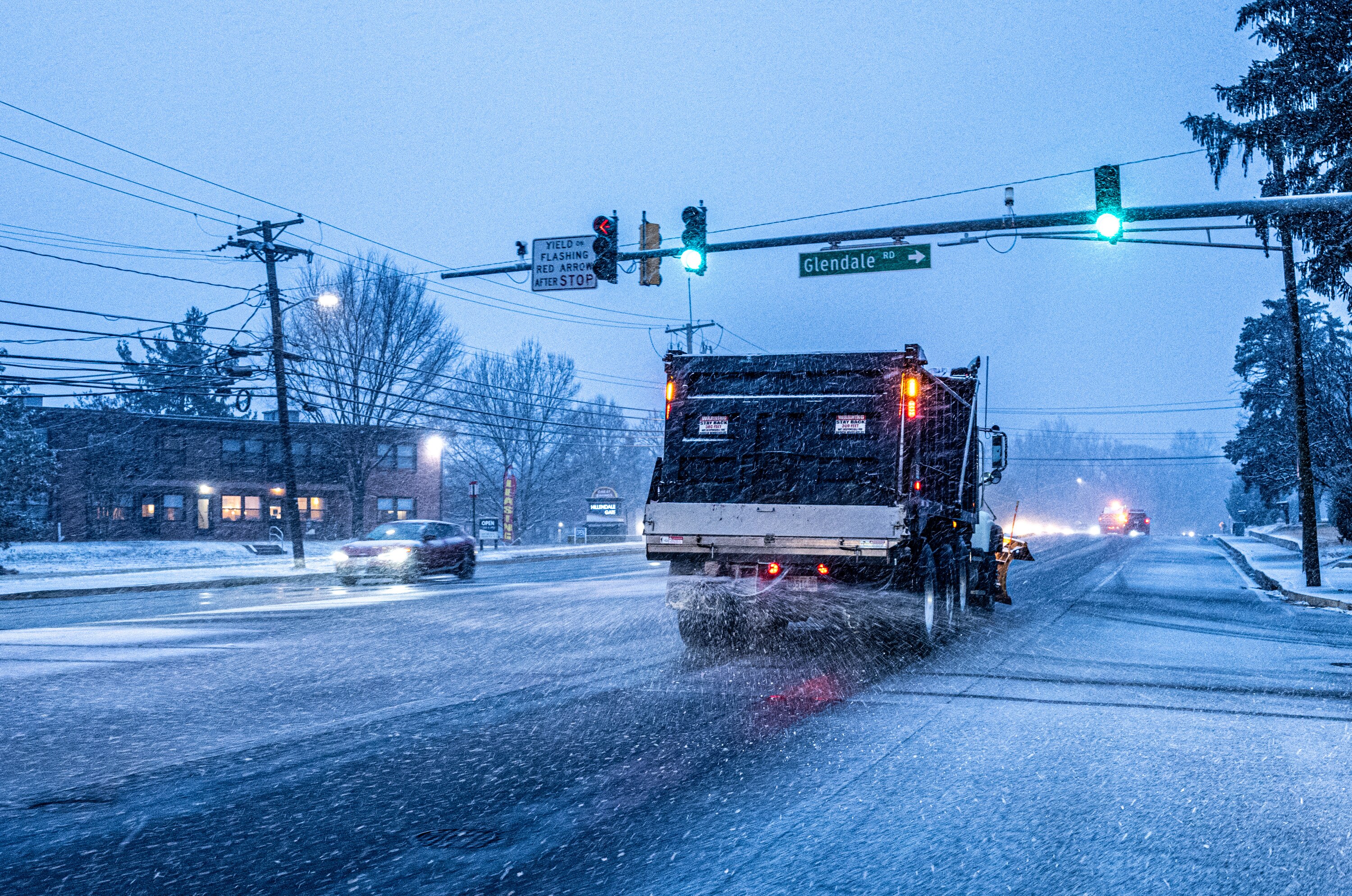 A snow plow spreads salt on Loch Raven Boulevard in Towson as snow begins to stick late Tuesday, February 11, 2025.