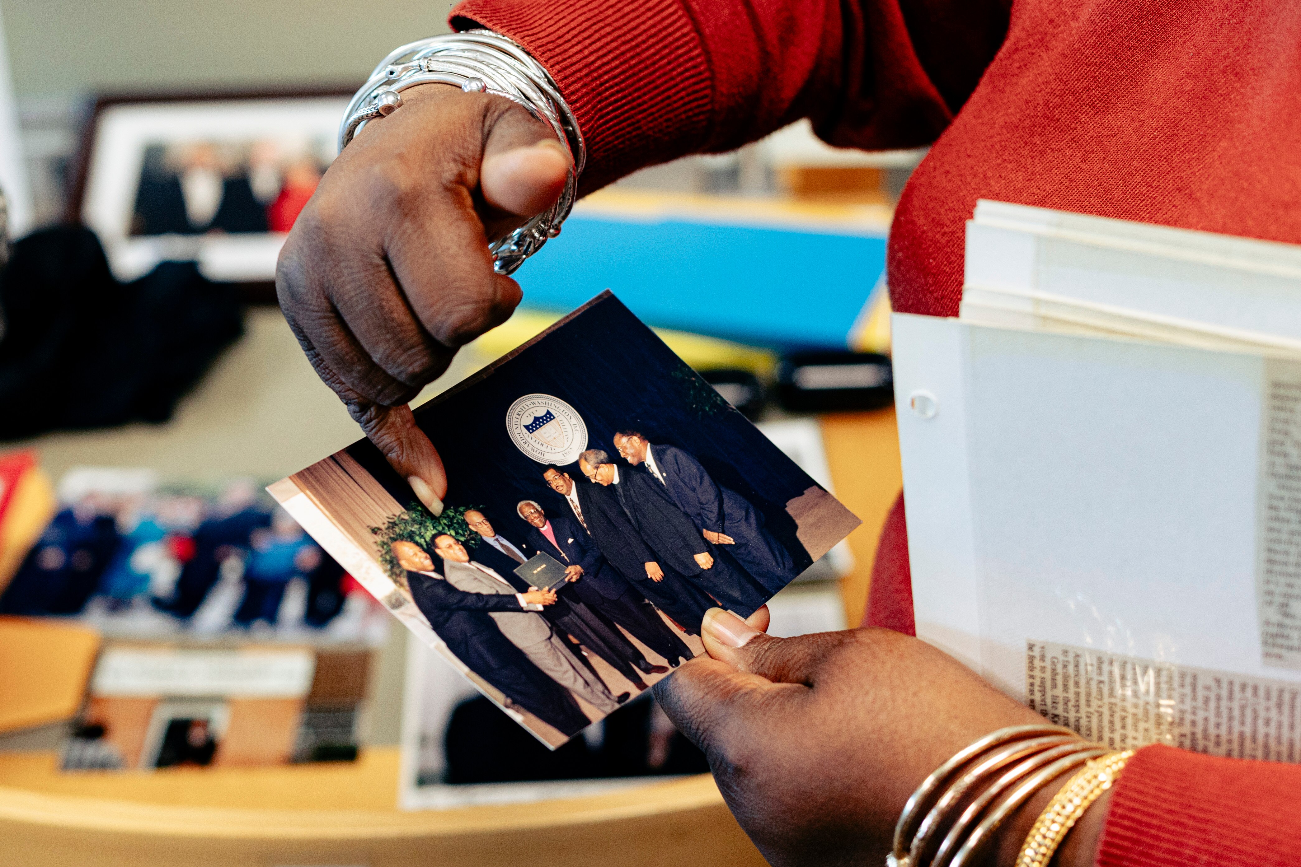 Dr. Ida Jones, an archivist and associate director of special ollections at Morgan State University, holds a photo of the late U.S. Rep. Elijah Cummings standing with South African bishop and theologian Desmond Tutu and others. The photo is from the new personal collection of Cummings’ documents to be archived and exhibited in Morgan State’s Beulah M. Davis Special Collections Room.