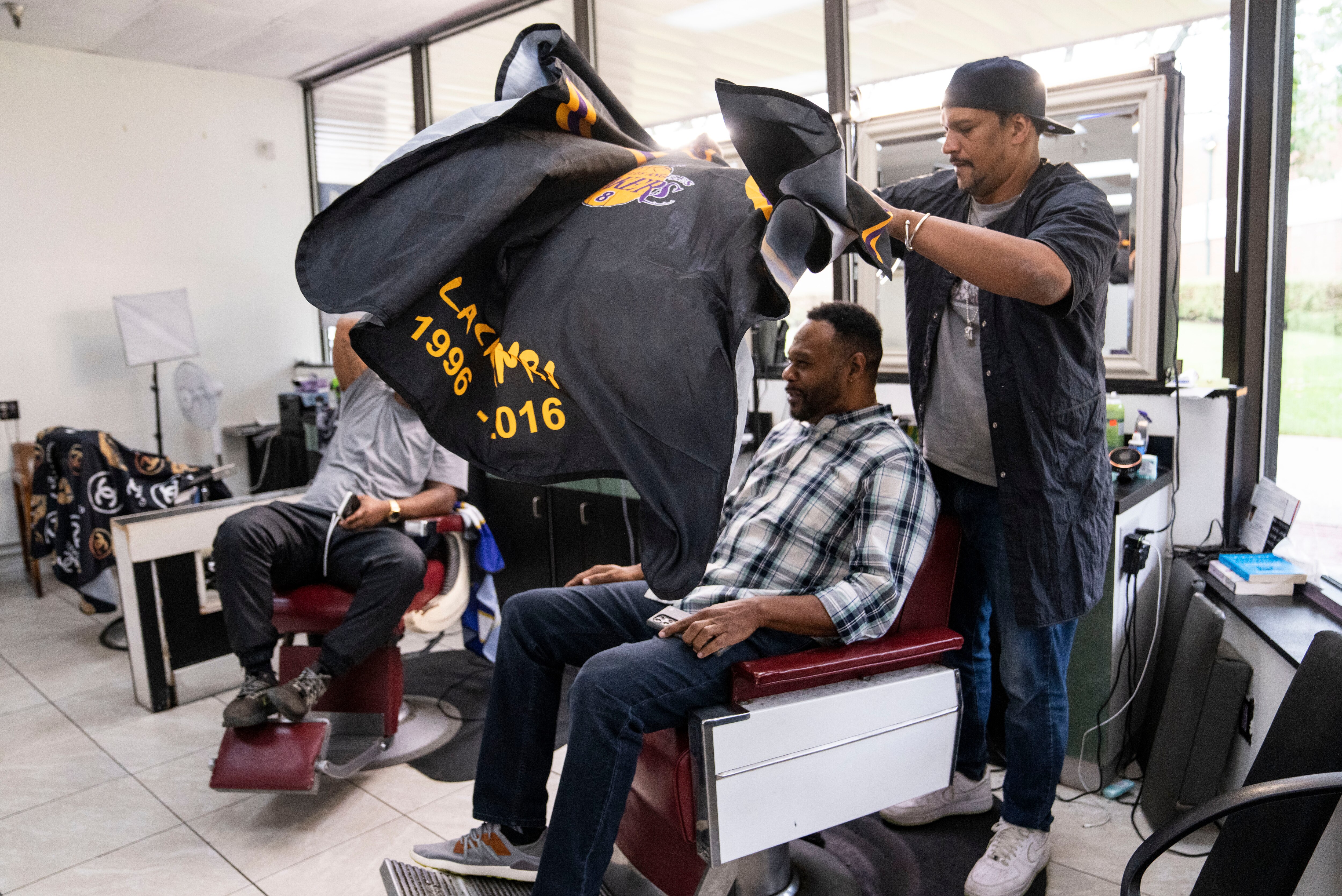 David Clark puts a cape over a customer before a haircut at Warren’s Barbershop in Columbia. Warren's, the first Black-owned barbershop in Howard County, recently celebrated 100 years in business.