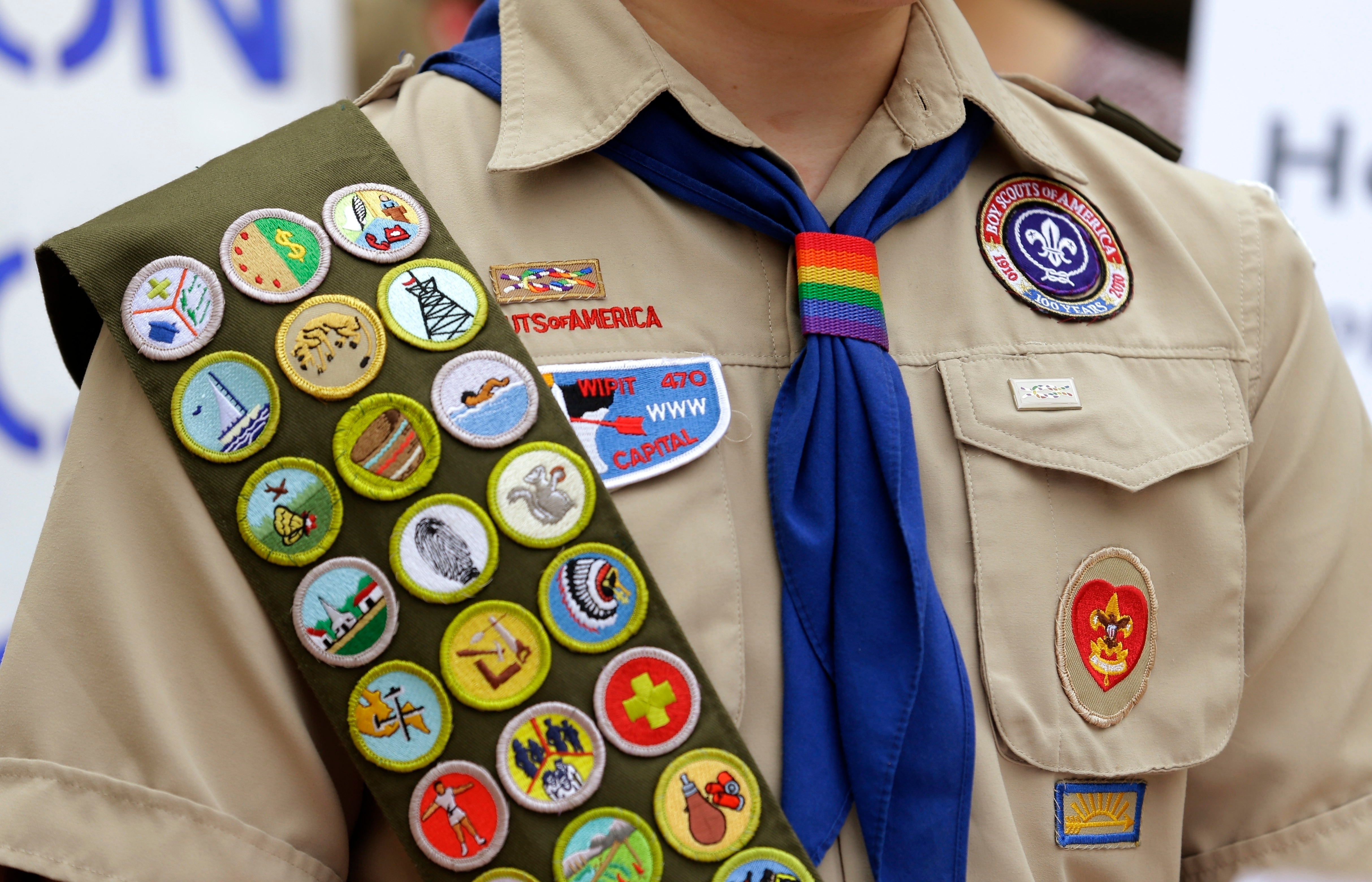 Merit badges and a rainbow-colored neckerchief slider are affixed on a Boy Scout uniform outside the headquarters of Amazon in Seattle on Jul 23, 2021.
