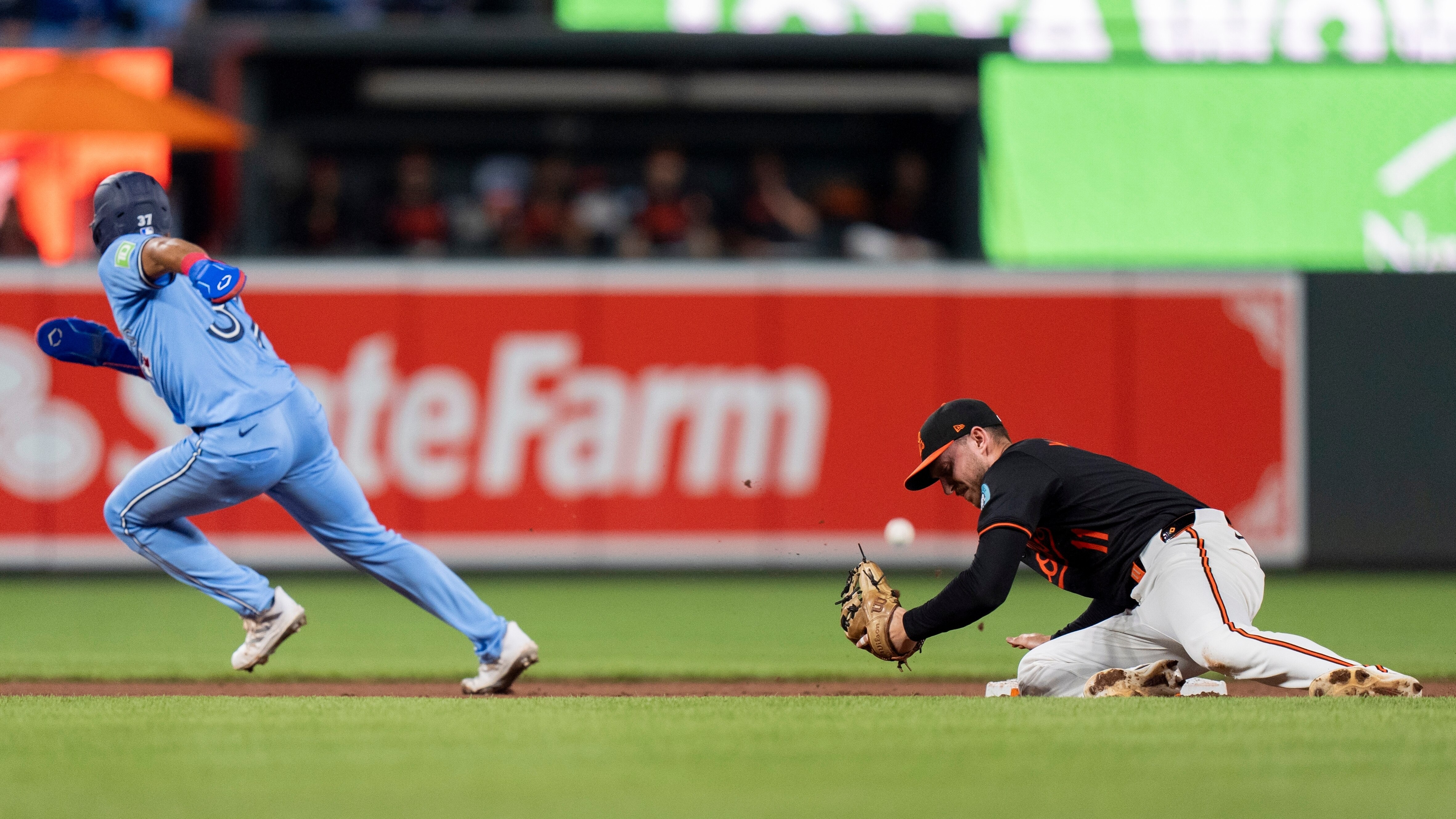 Toronto Blue Jays' Steward Berroa, left, advances toward third base on a fielding error by Baltimore Orioles shortstop Jordan Westburg, right, after stealing second during the second inning in the second baseball game of a doubleheader, Monday, July 29, 2024, in Baltimore. (AP Photo/Stephanie Scarbrough)