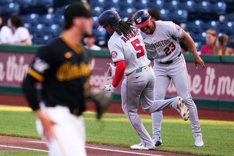 Washington Nationals' CJ Abrams (5) is greeted by first base coach Corey Ray (23) as he rounds first after hitting a solo home run off Pittsburgh Pirates pitcher Paul Skenes, left, during the first inning of a baseball game in Pittsburgh, Monday, April 13, 2026.