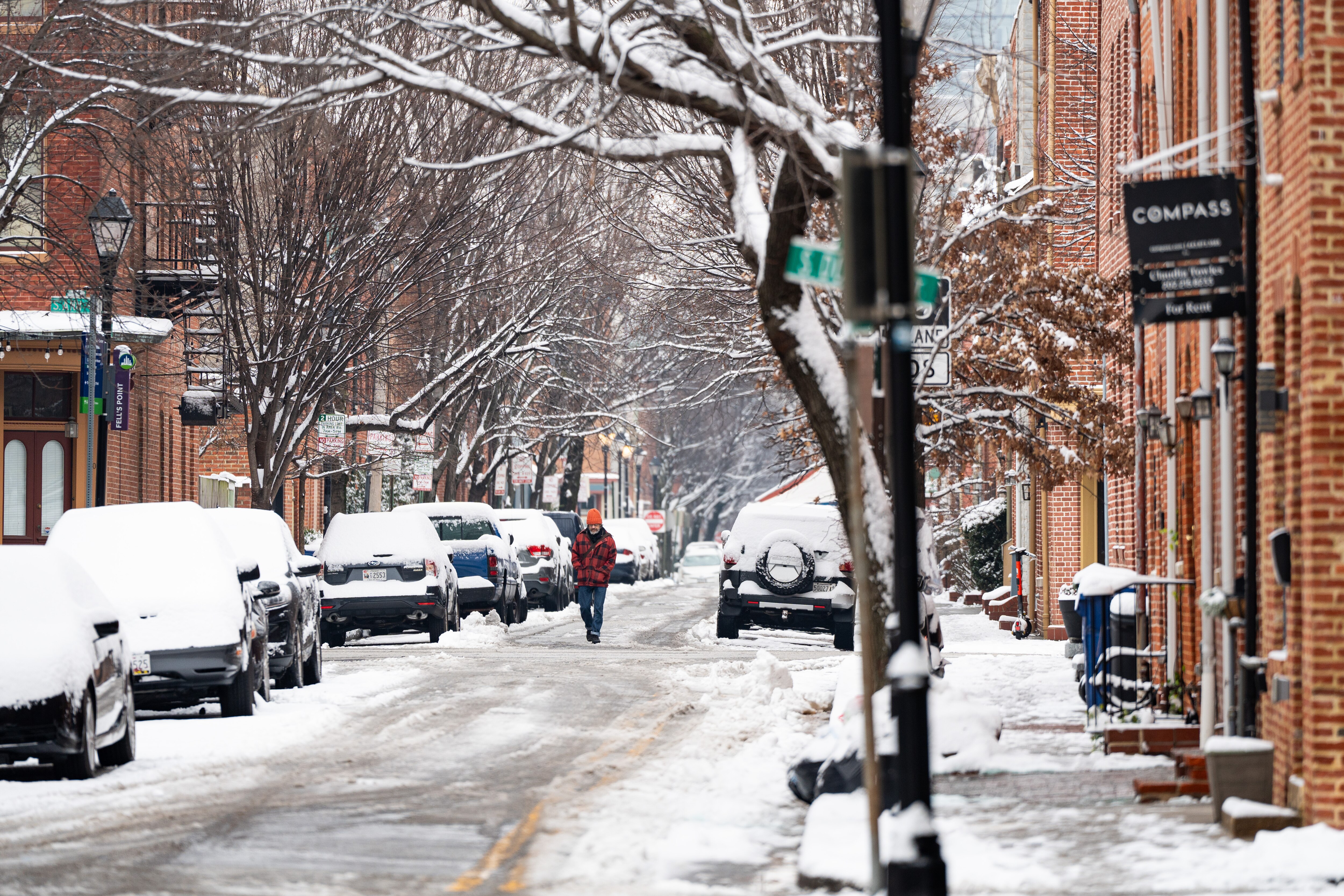 A man walks down a street in Fells Point on Tuesday, Jan. 16, 2024. Baltimore received about 4 inches of snow.