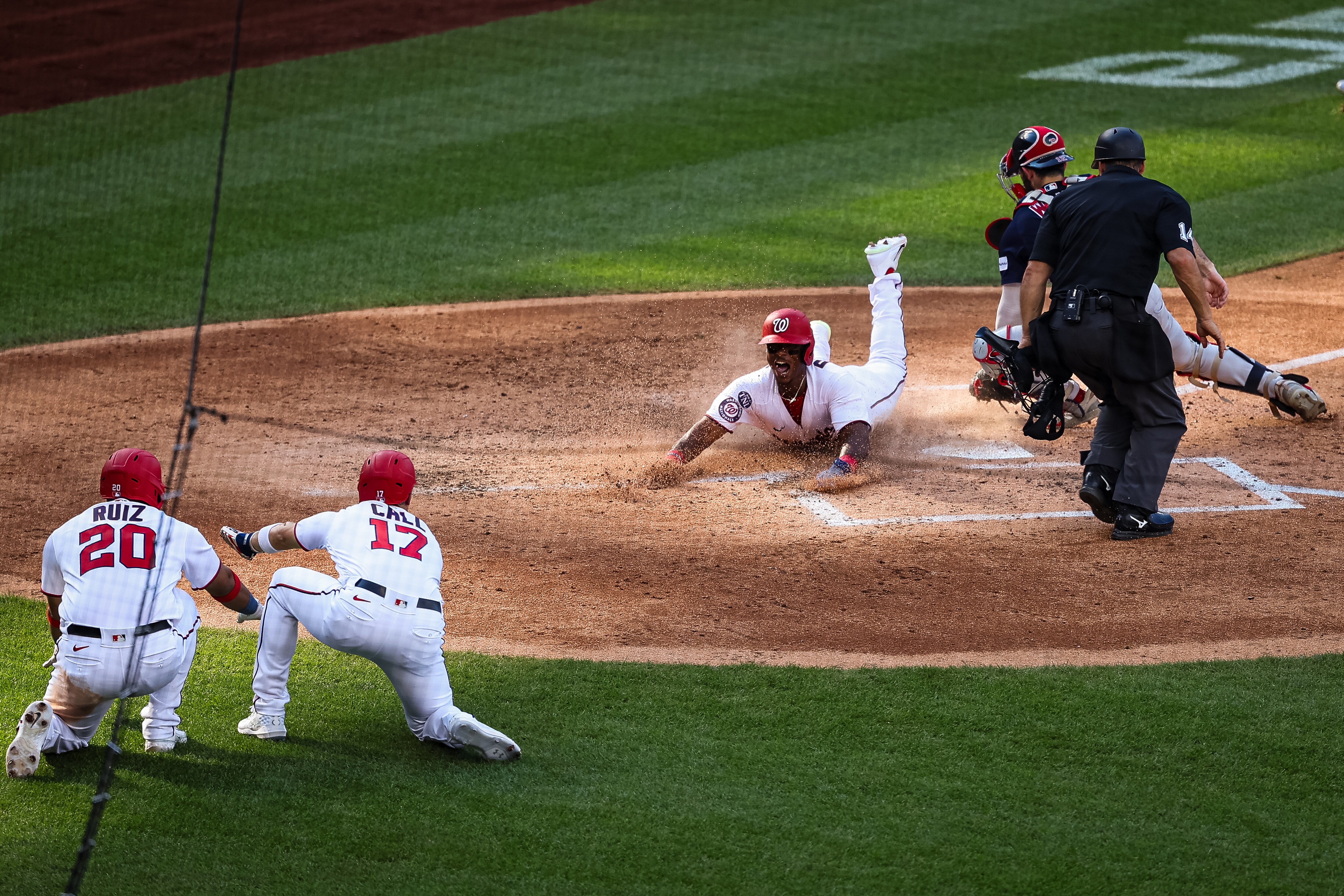 Jeter Downs of the Nationals scores a run in the fifth inning as teammates Keibert Ruiz and Alex Call call him safe.