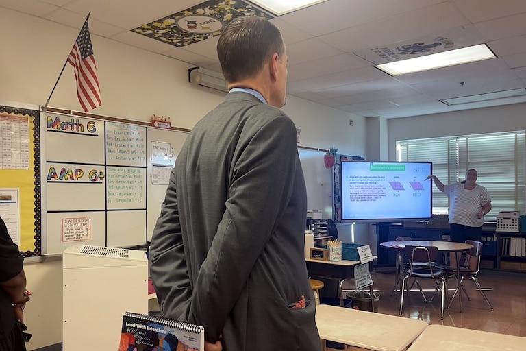 Superintendent Thomas Taylor observes a sixth-grade math class at John Poole Middle School in early September. He holds a booklet, dubbed Lead with Intention, that outlines exactly what the students should be learning.