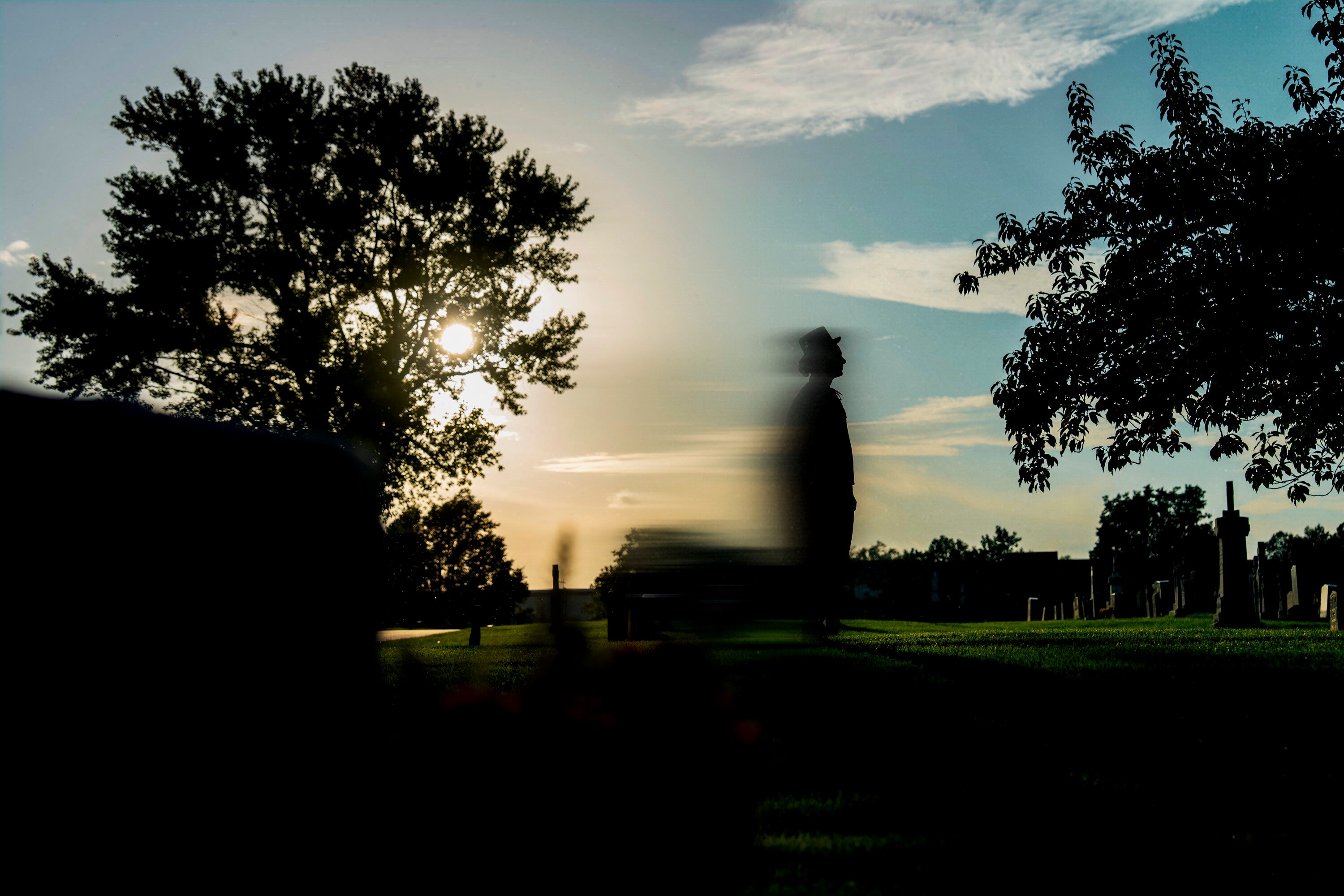 A model stands in Saint Stanislaus Cemetery in O'Donnell Heights in a top hat and cape, the same outfit that witnesses claim the O'Donnell Heights Phantom was wearing.