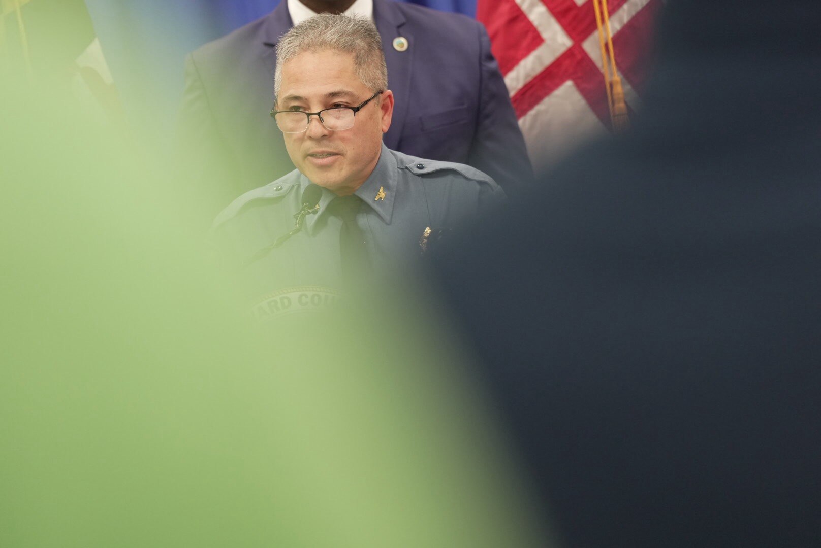 Gregory Der, Howard County Police Chief, holds up a photo of a suspect wanted in the 2024 Columbia Mall shooting during a press conference where he discusses recent crime on February 27, 2025.