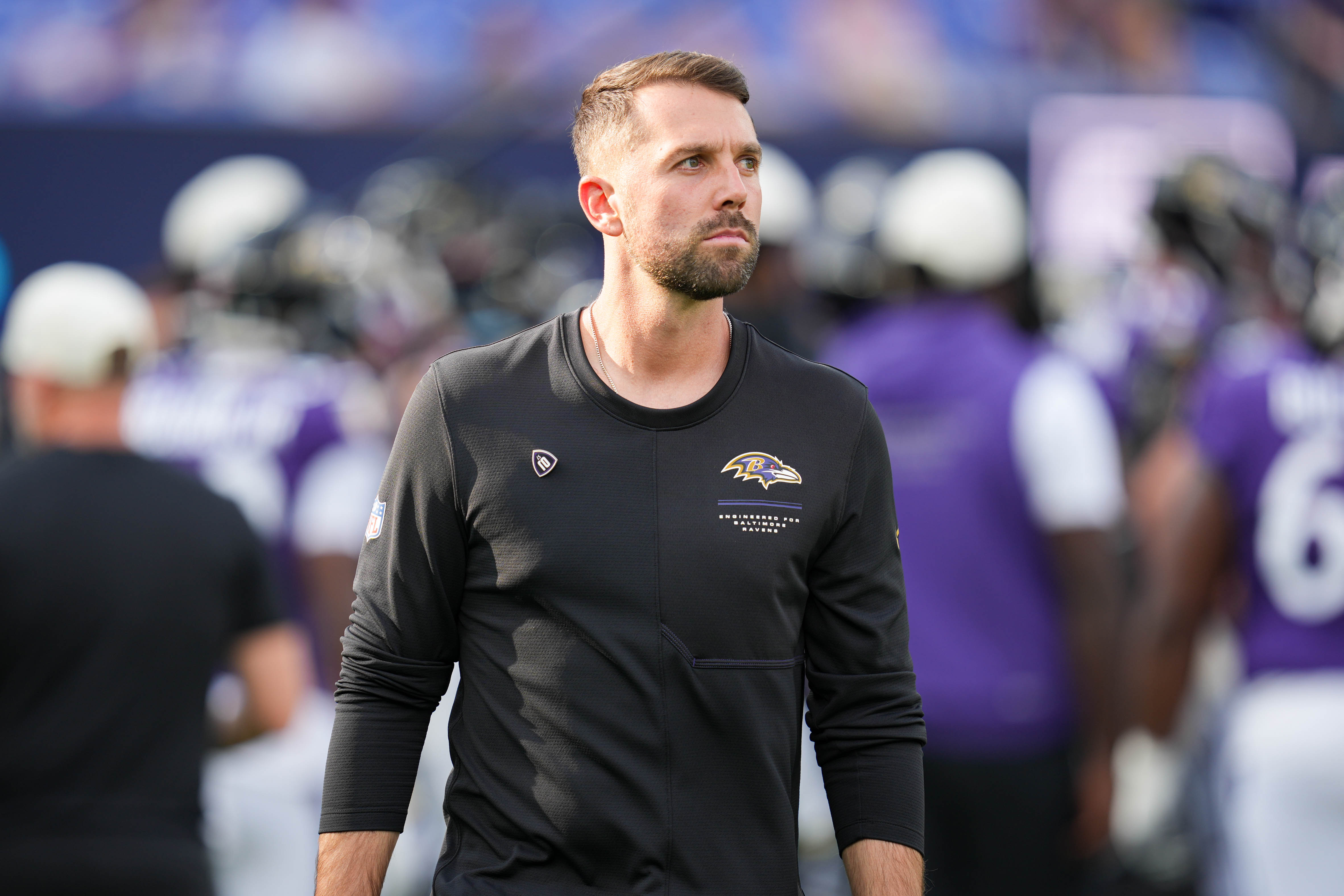 Ravens offensive coordinator Declan Doyle watches his players warm up ahead of a preseason game against the Washington Commanders last month.