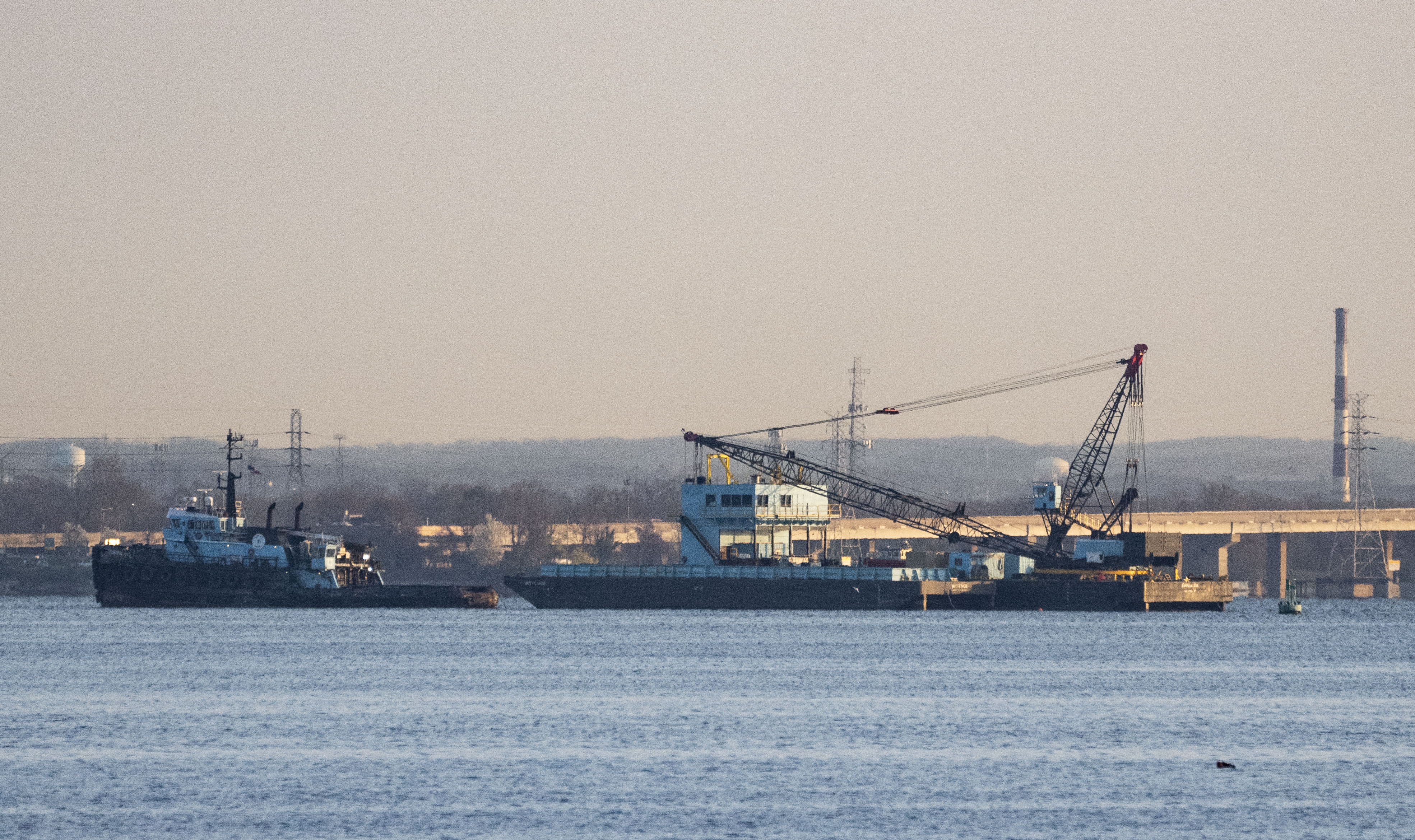 A crane is seen near the wreckage of the Francis Scott Key Bridge on Friday, March 29, 2024.