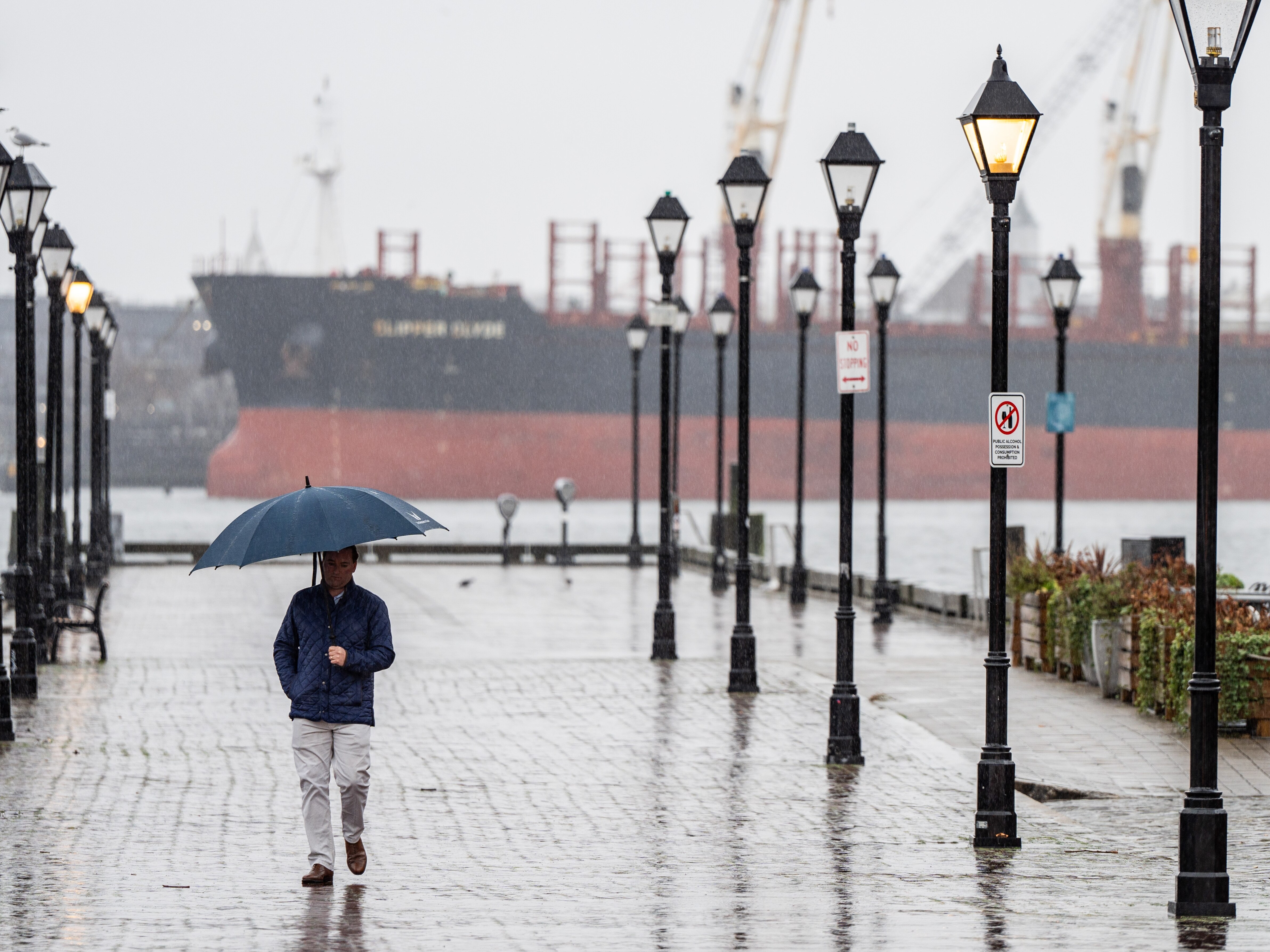 A person walks through Fells Point on a rainy Tuesday, Jan. 9, 2024.