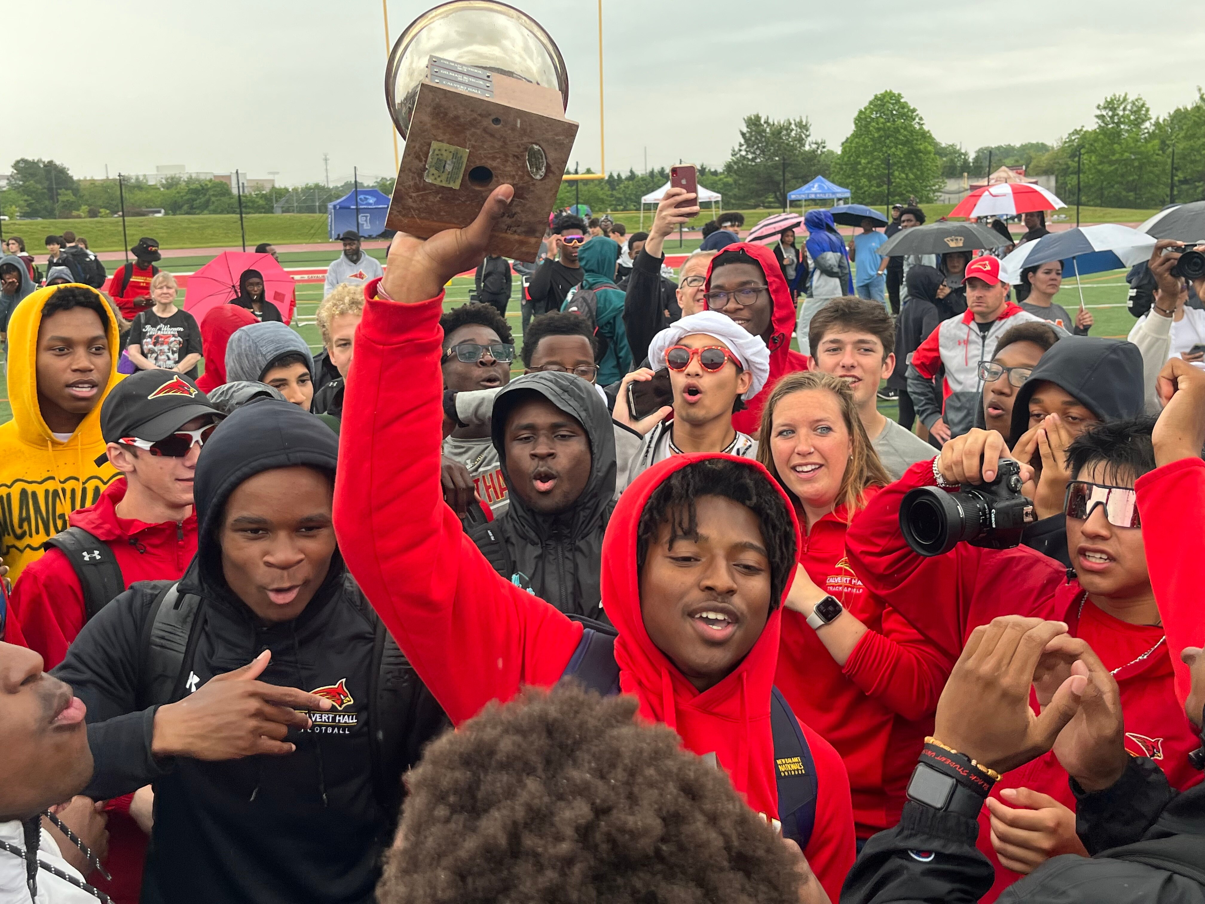 Calvert Hall senior Ricardo Cooper holds up the MIAA A Conference outdoor track championship trophy Saturday. The Cardinals won their second straight championship after going 23 years without a title.