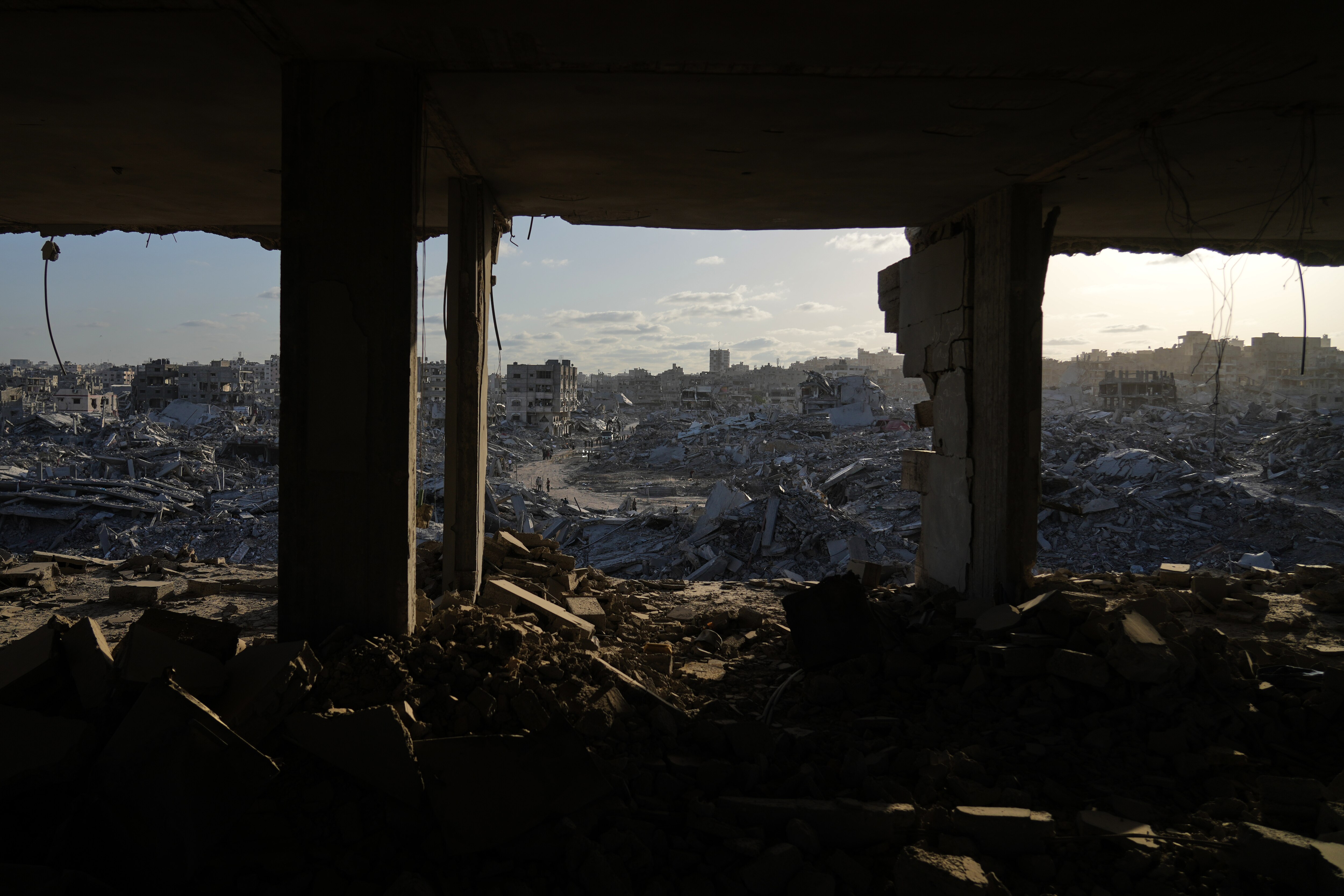 Displaced Palestinians walk amid destroyed buildings in the heavily damaged Sheikh Radwan neighborhood in Gaza City, Saturday, Oct. 11, 2025, after Israel and Hamas agreed to a pause in their war and the release of the remaining hostages.