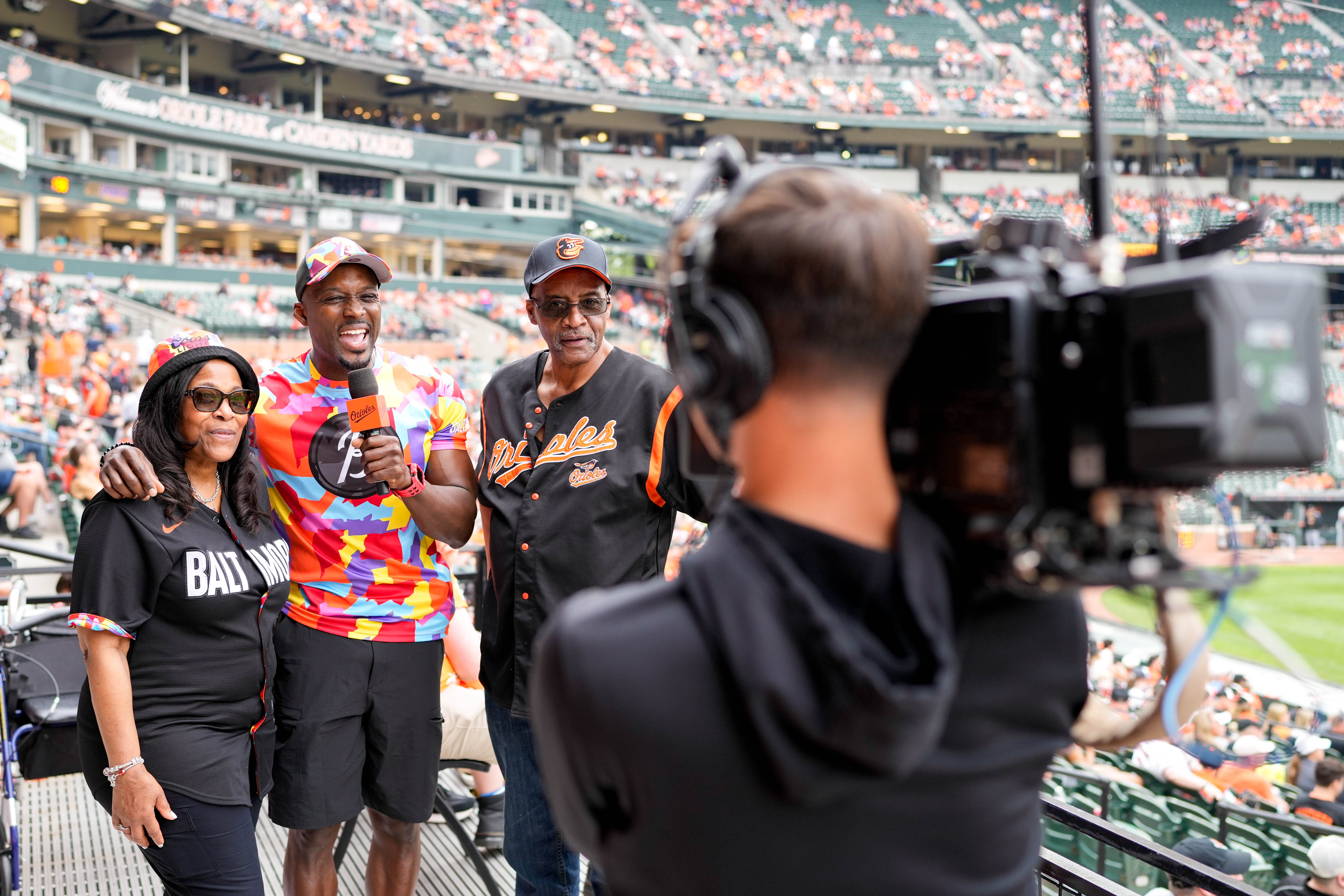 Orioles in-game entertainment host Dennis T, center left, with contestants Karen Freeman and Wayne Turner for a challenge between innings of a recent game against the White Sox.