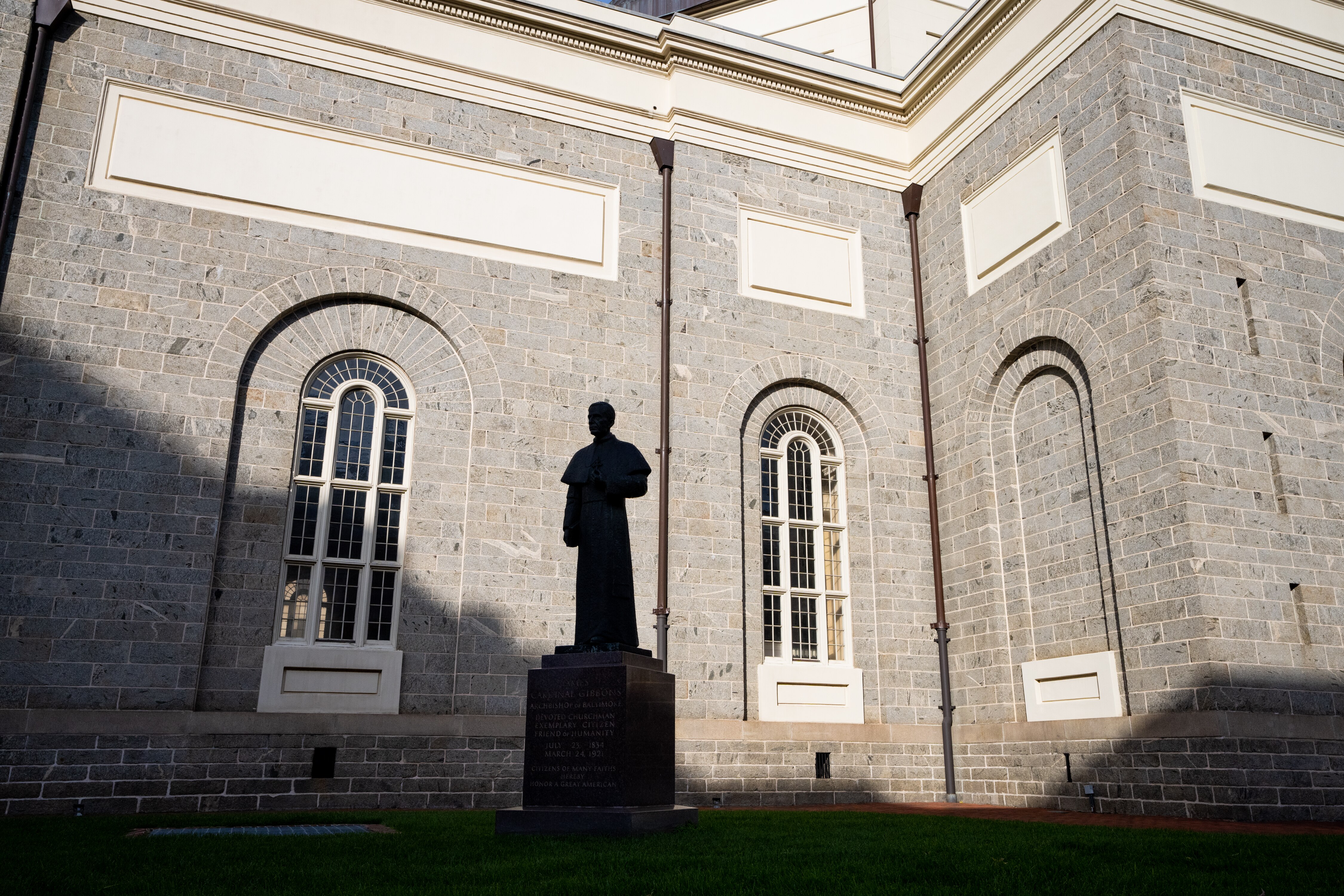 A statue of Cardinal James Gibbons stands on the side of The Baltimore Basilica, on December 2, 2022.