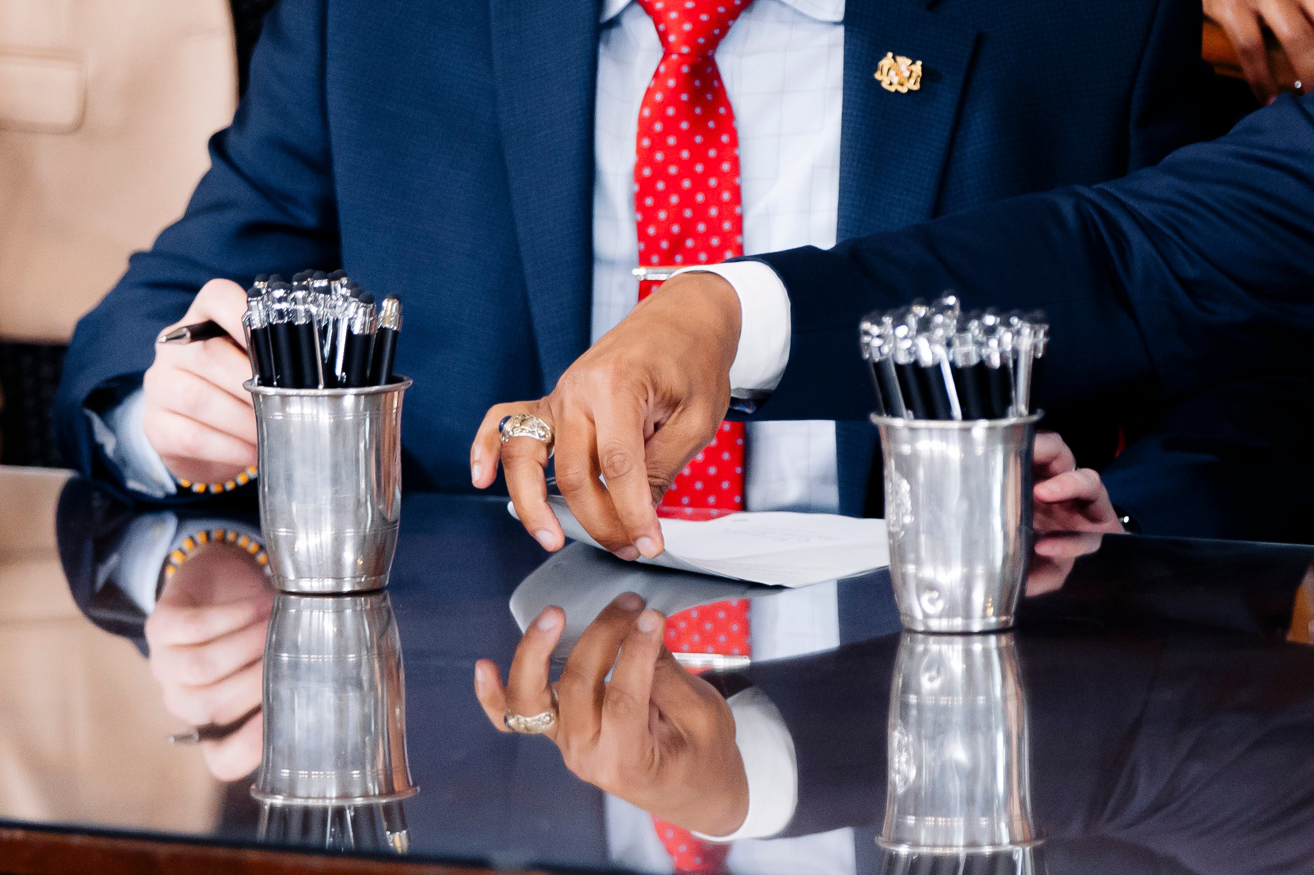 Gov. Wes Moore passes a bill to Senate President Bill Ferguson after signing it into law at a signing ceremony following the conclusion of the 2024 Maryland General Assembly at the Maryland State House on Tuesday, April 9, in Annapolis.