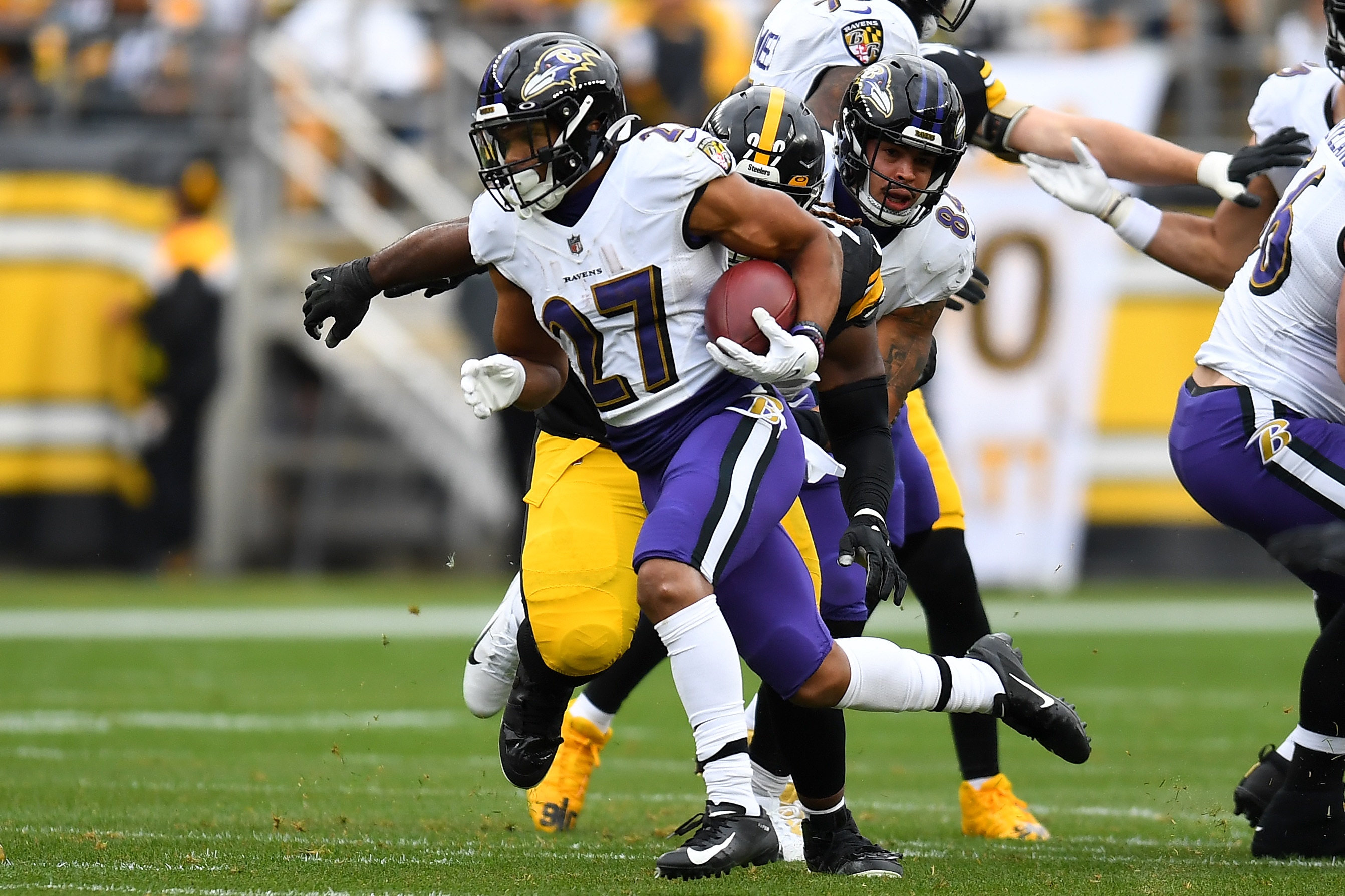 PITTSBURGH, PENNSYLVANIA - DECEMBER 11: J.K. Dobbins #27 of the Baltimore Ravens	runs for a first down during the first quarter of the game against the Pittsburgh Steelers at Acrisure Stadium on December 11, 2022 in Pittsburgh, Pennsylvania. (Photo by Joe Sargent/Getty Images)