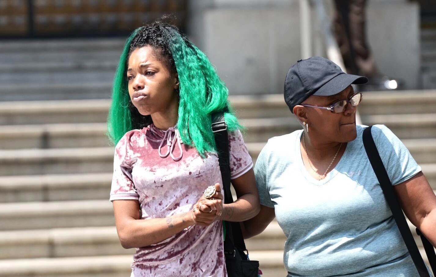 In this photo from July 27, 2023, Aijah Gatson, left, the mother of a 16-year-old found guilty of voluntary manslaughter in the deadly shooting of Timothy Reynolds, 48, of Hampden, leaves the Clarence M. Mitchell Jr. Courthouse in Baltimore after a jury returned a verdict in the case.