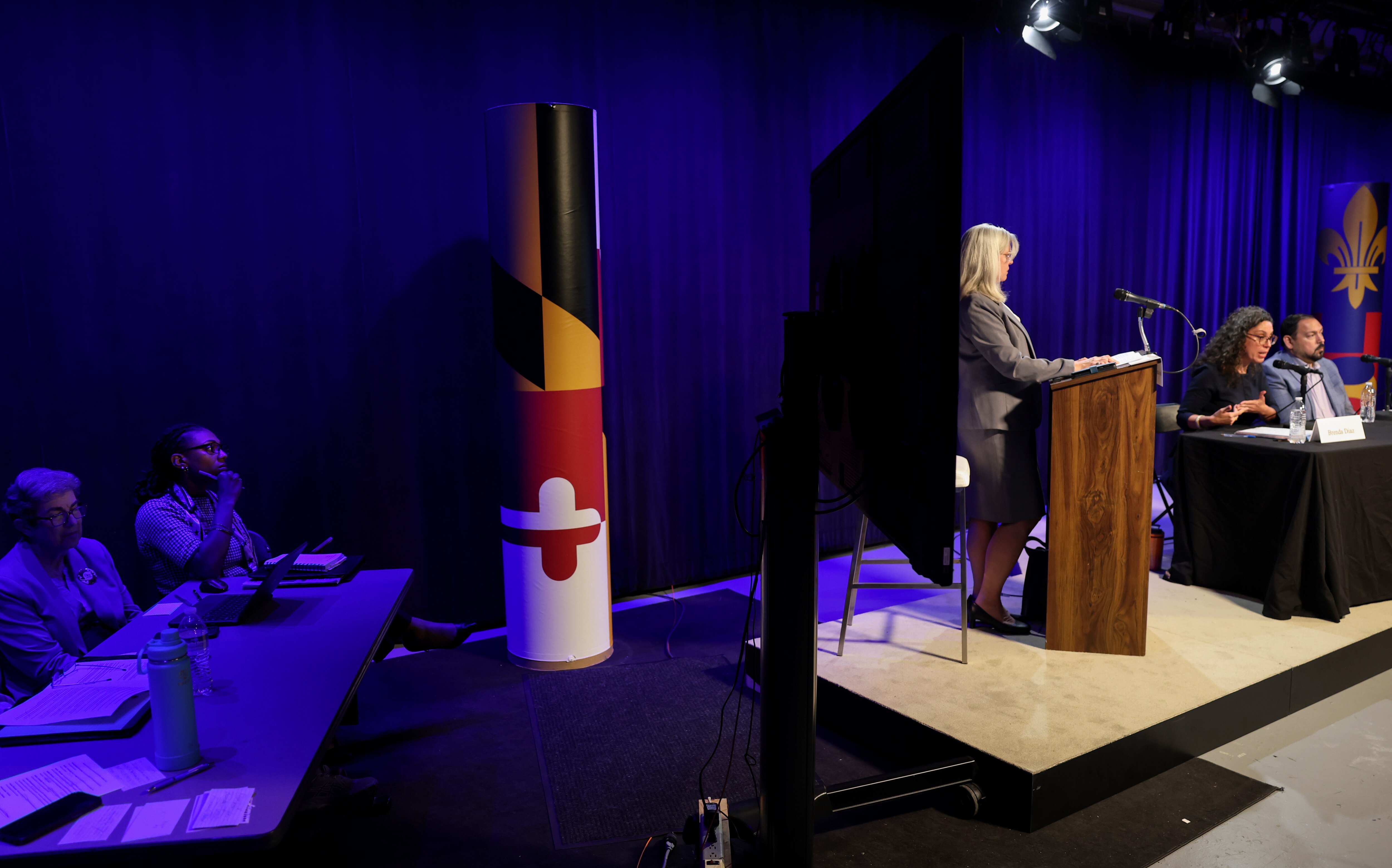 Moderator Sonya Laurence Green, at podium, listens to Montgomery County Board of Education candidate Brenda Diaz respond to questions next to Omar Lazo, right, during a forum hosted by the League of Women Voters at the Montgomery Community Television, Inc. Studios in Rockville on Wednesday.